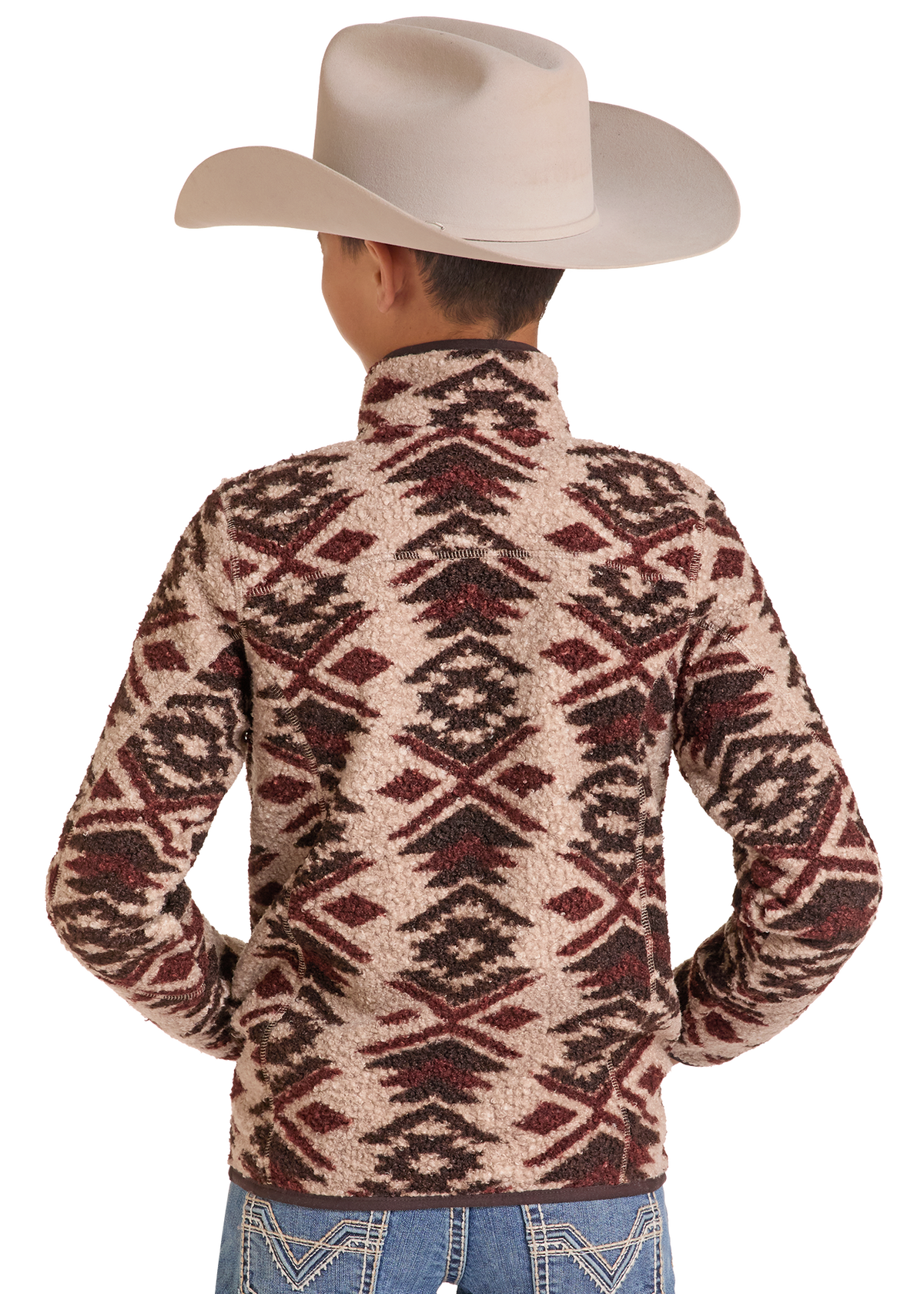 A child viewed from the back wearing a cream cowboy hat and a patterned sherpa fleece pullover. The pullover features a geometric Southwestern-style diamond and zigzag pattern in dark brown and burgundy red on a warm beige background.