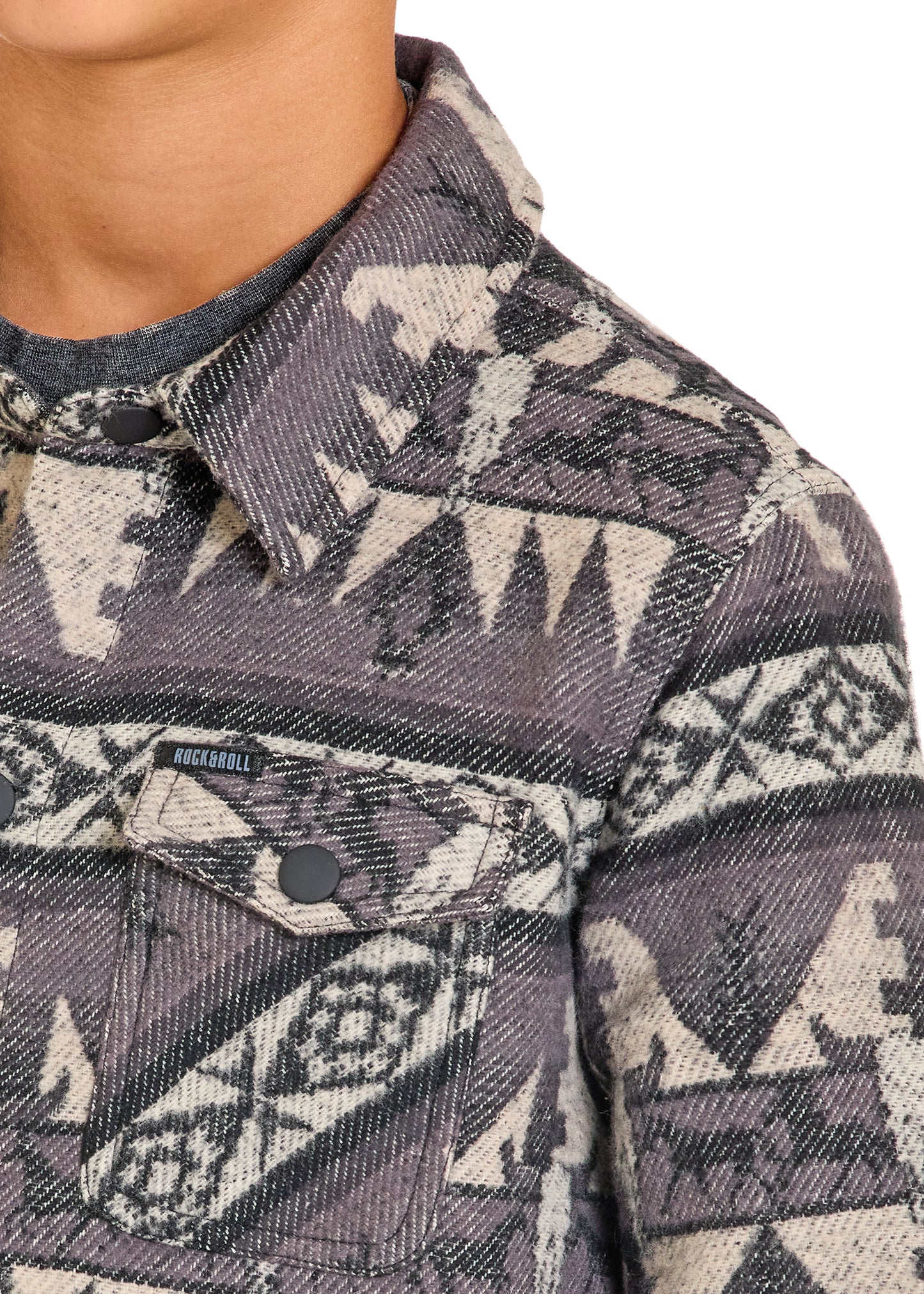 Close-up of a patterned denim jacket with a brand logo on a white background