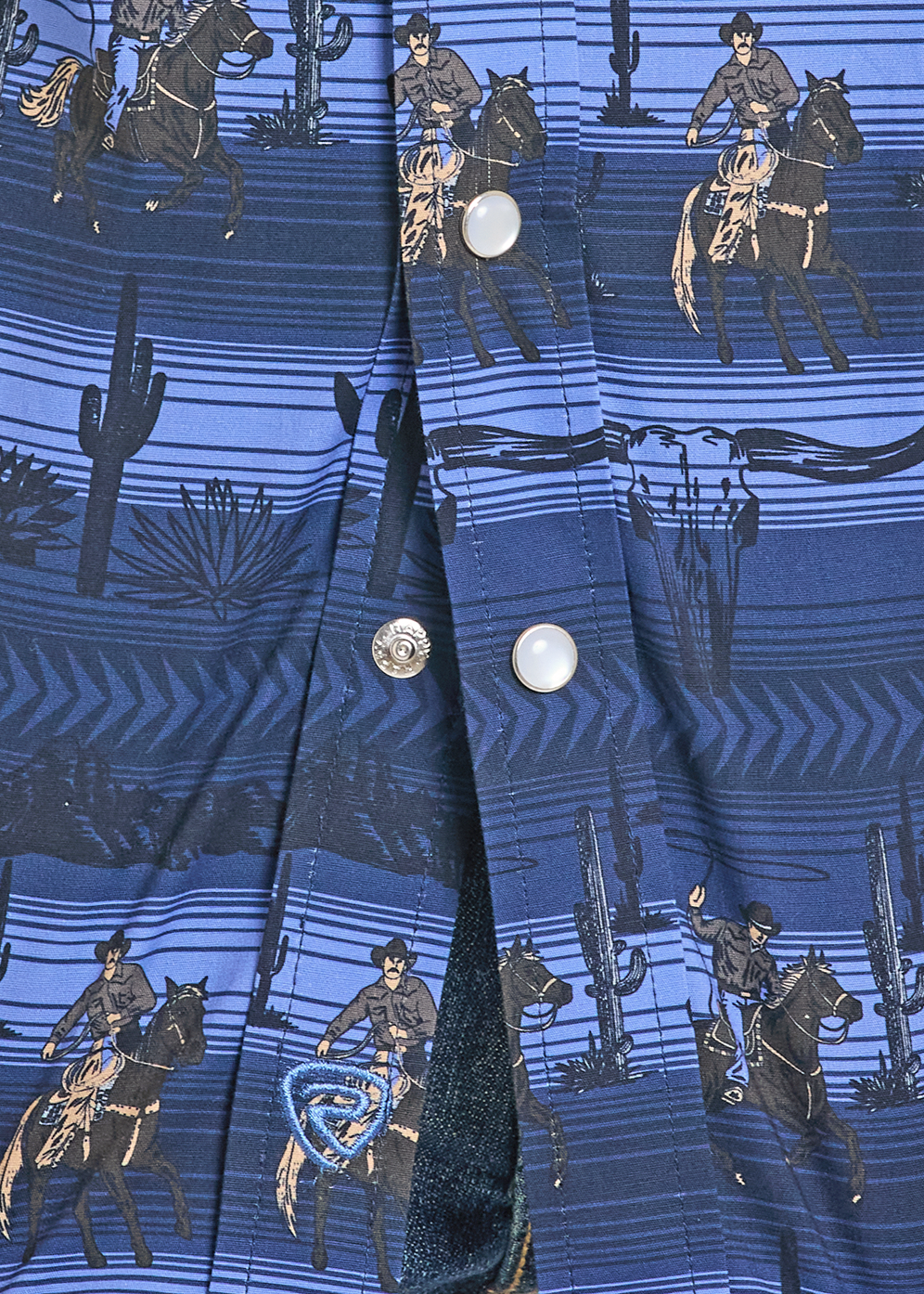 Close-up of a blue shirt with cowboy pattern held by hands on a white background