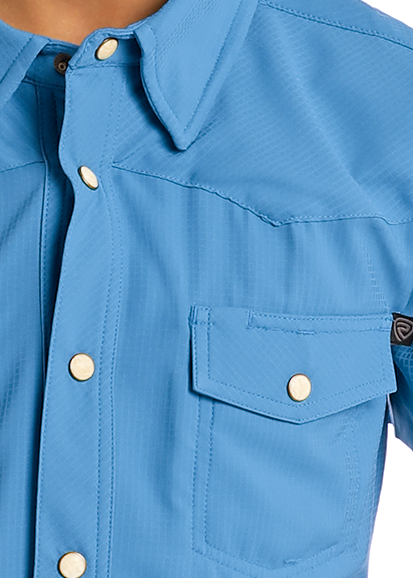 Boy wearing a blue shirt with pearl snaps on a white background