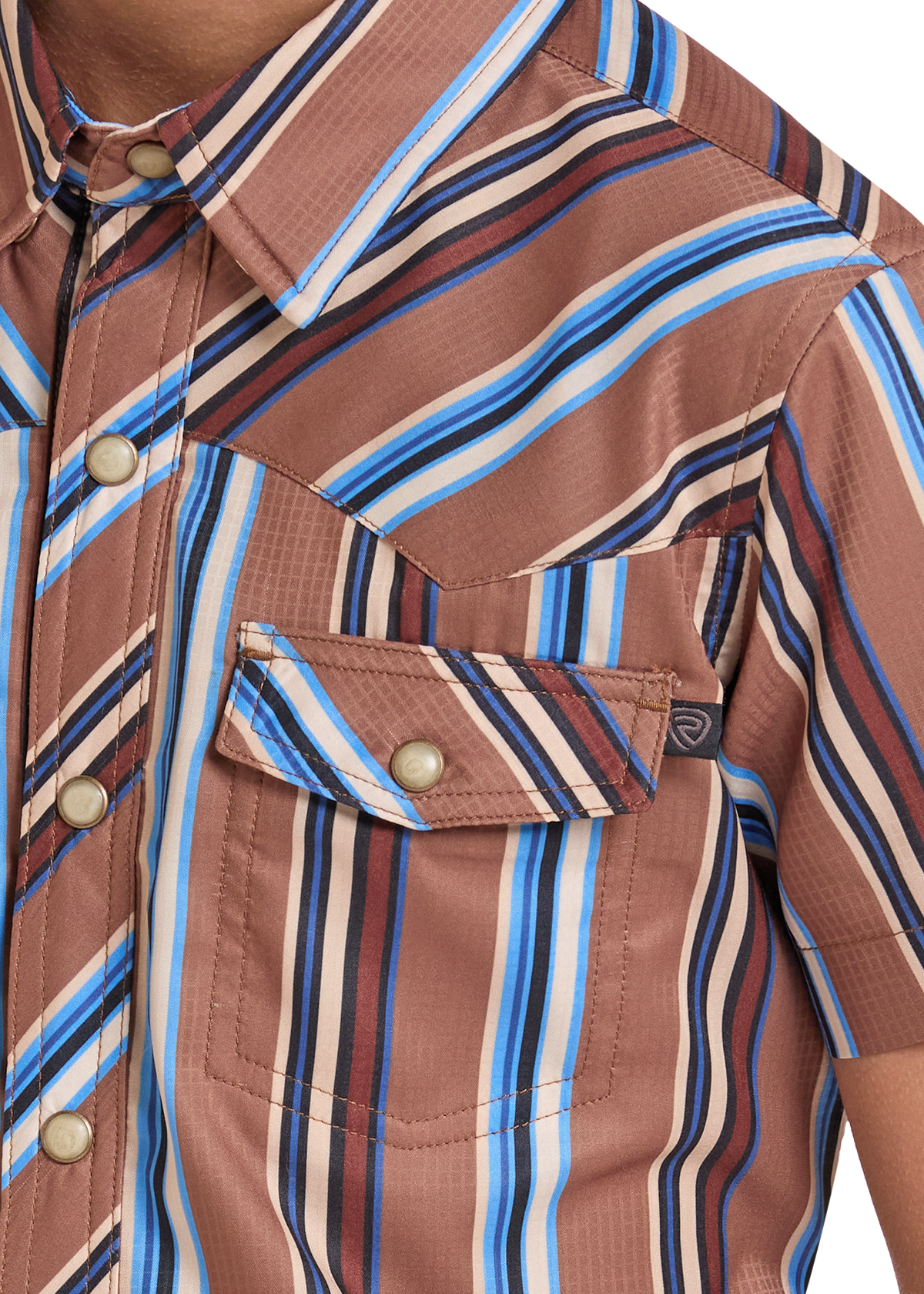 Close-up of a man wearing a short-sleeve button-up shirt with vertical brown, beige, blue, and white stripes. The shirt features a chest pocket with a buttoned flap and a small dark brand tag.