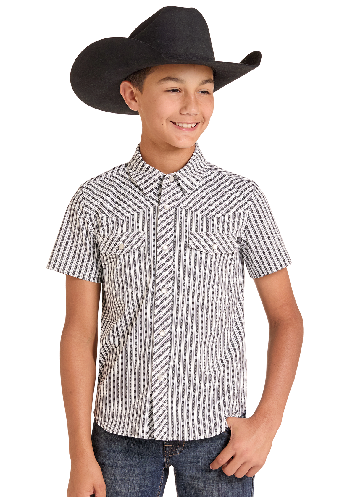 A young boy modeling a black and white patterned short-sleeve western shirt with a black cowboy hat and blue jeans, set against a plain white background.