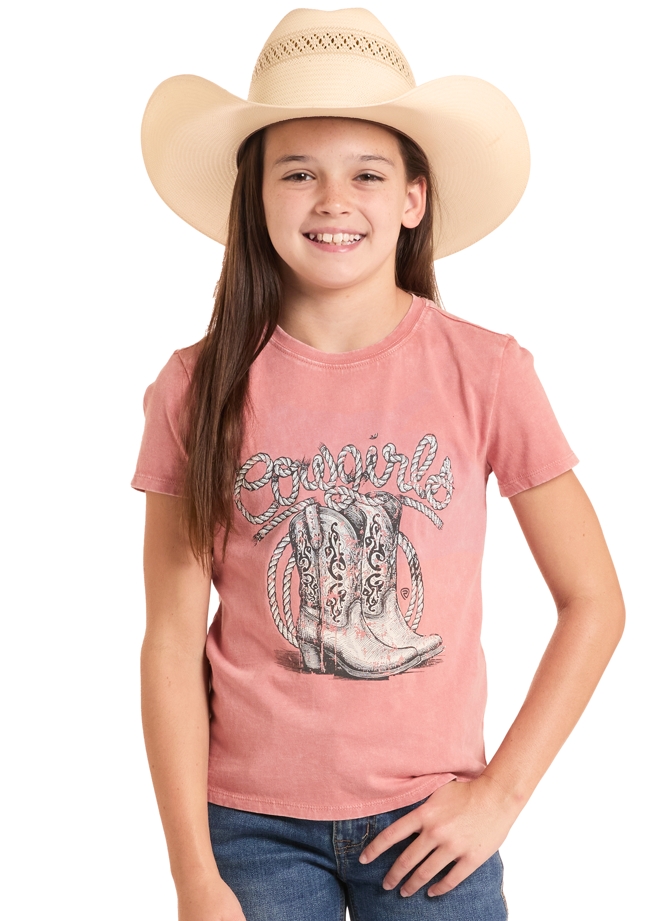 Young girl wearing a pink graphic t-shirt with cowboy boots and a hat on a white background