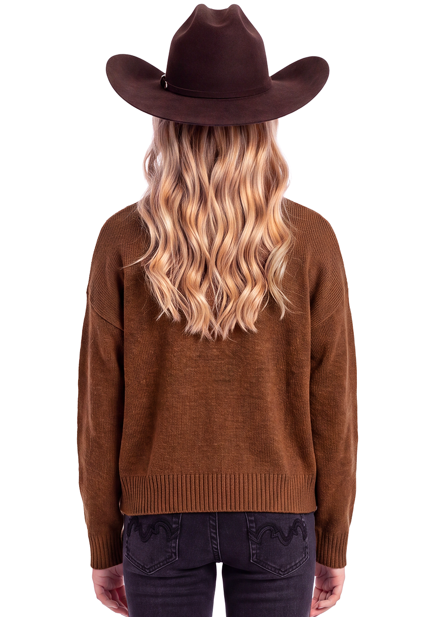 Rear view of a model wearing a brown knit sweater, dark jeans, and a brown cowboy hat against a plain white background.