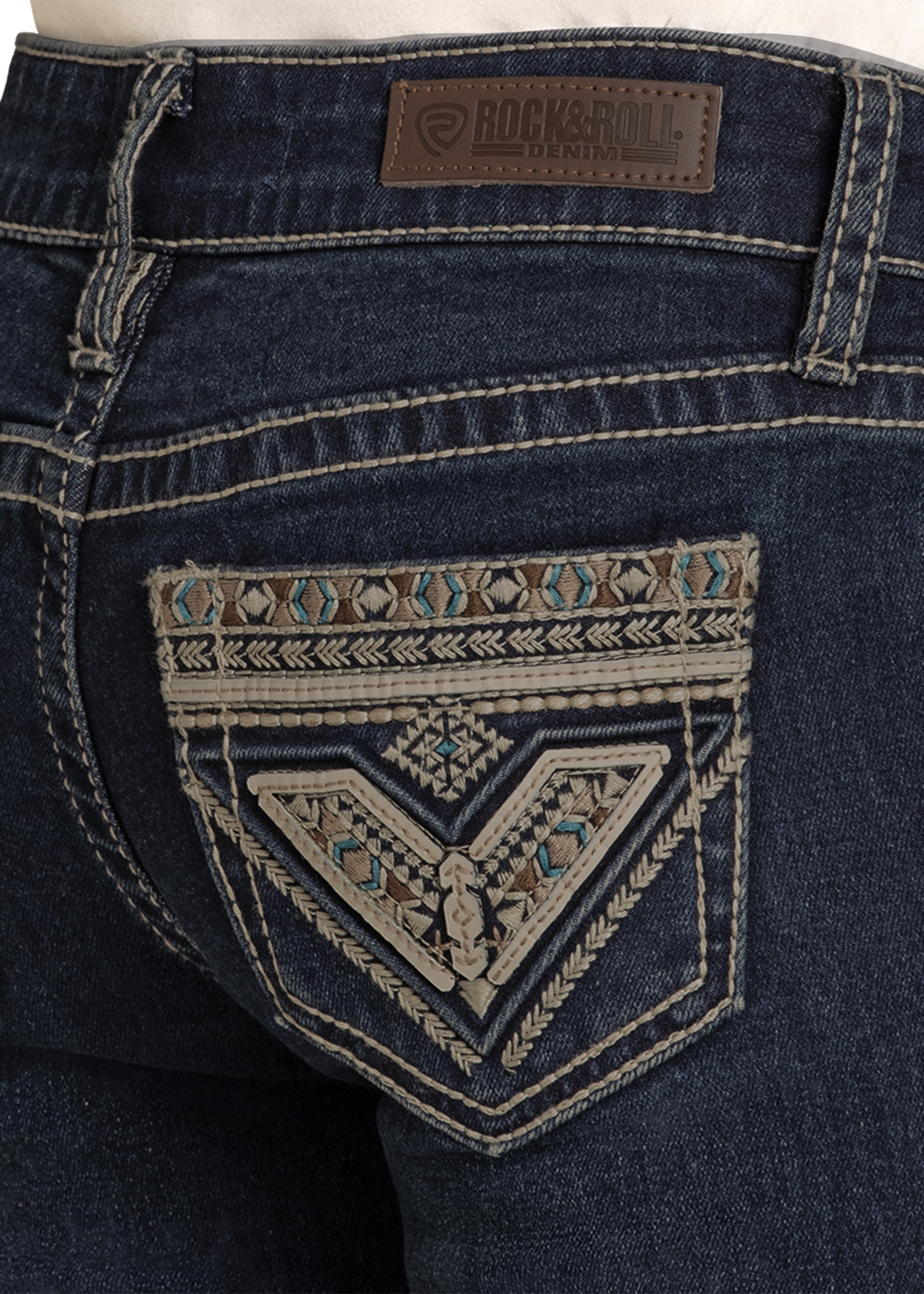 Close-up of dark blue jeans with a decorative pocket and Rock & Roll Hilltops brand label.
