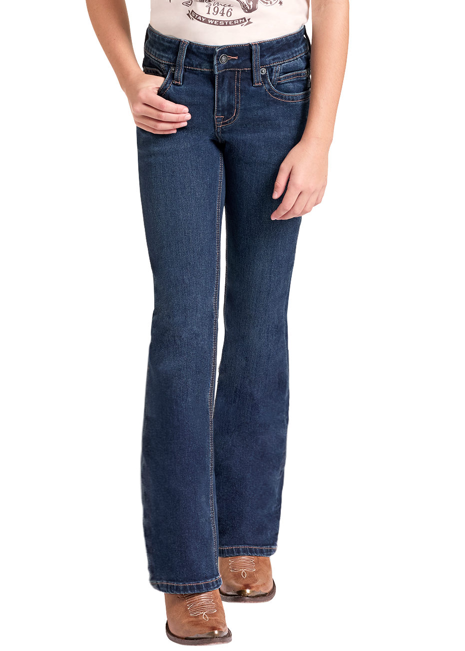 A young girl modeling a pair of dark blue western flare jeans, a cream and maroon raglan t-shirt with a western graphic, and a beige cowboy hat, standing against a solid white background.
