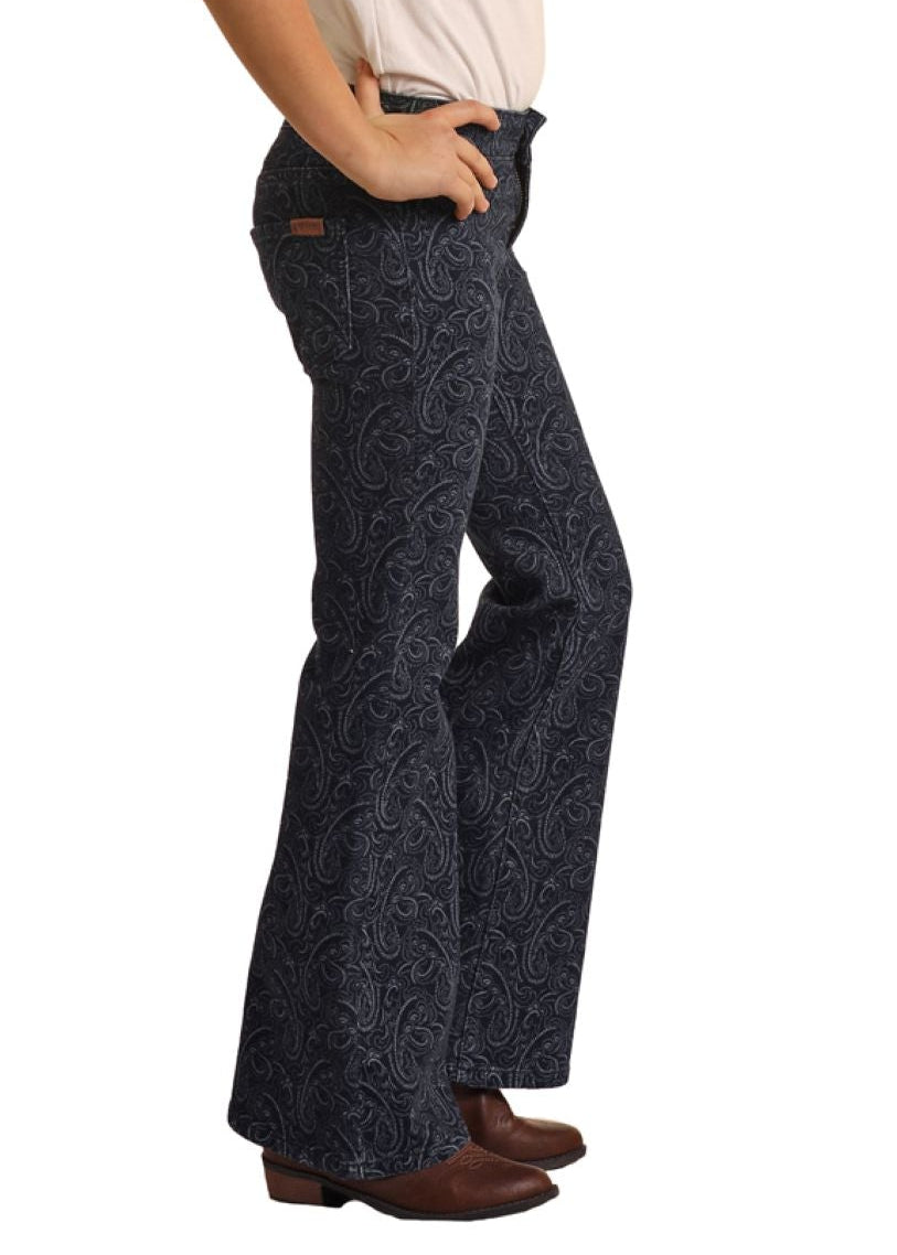 Person wearing a black hat and dark patterned pants on a white background