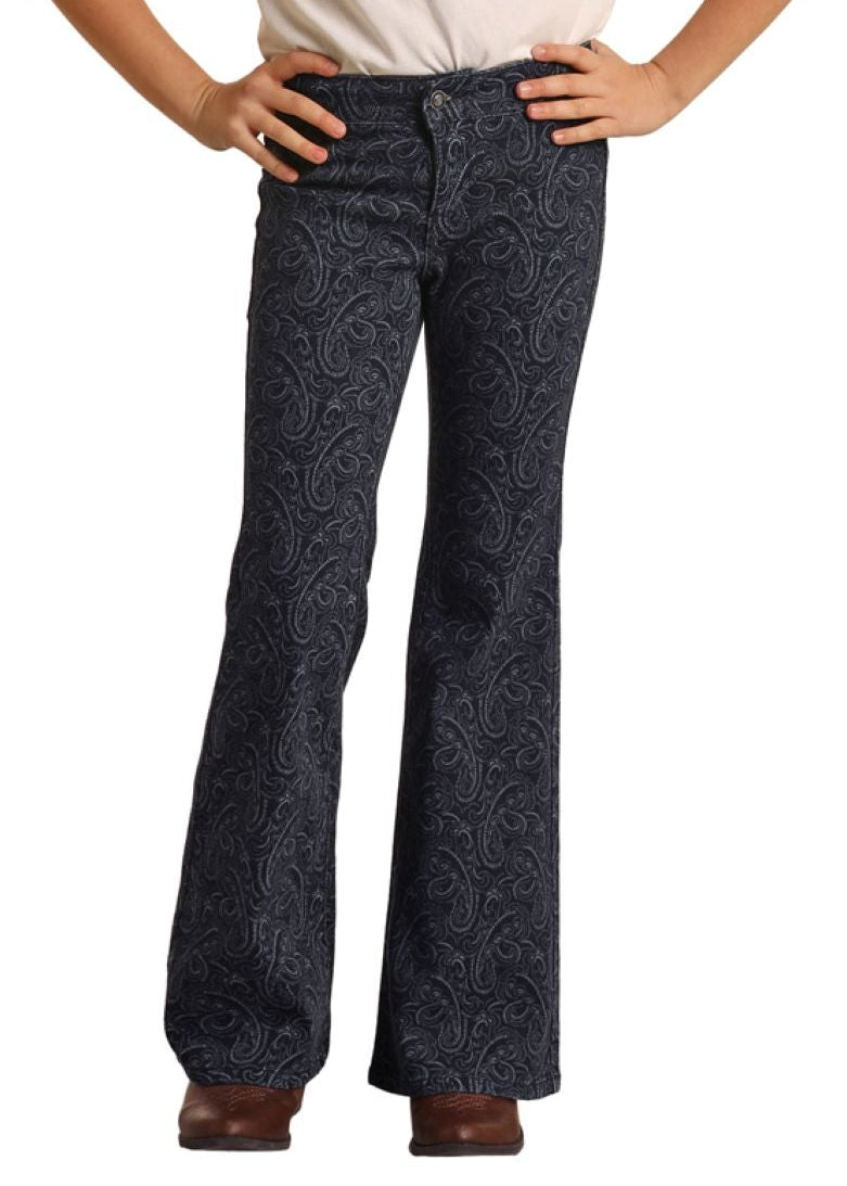 Young girl wearing a white t-shirt, black bell-bottom pants, and a black hat on a white background