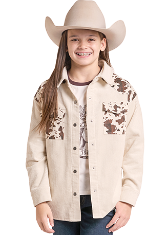 A young girl modeling a light beige western-style button-up shirt with brown cow-print embroidery on the chest.