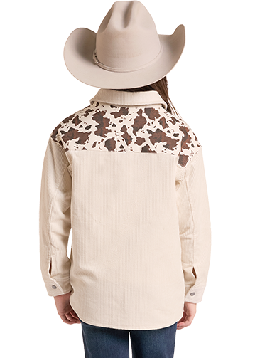 A child model shown from the back wearing a cream western shirt with brown and black cow-print yoke panels.