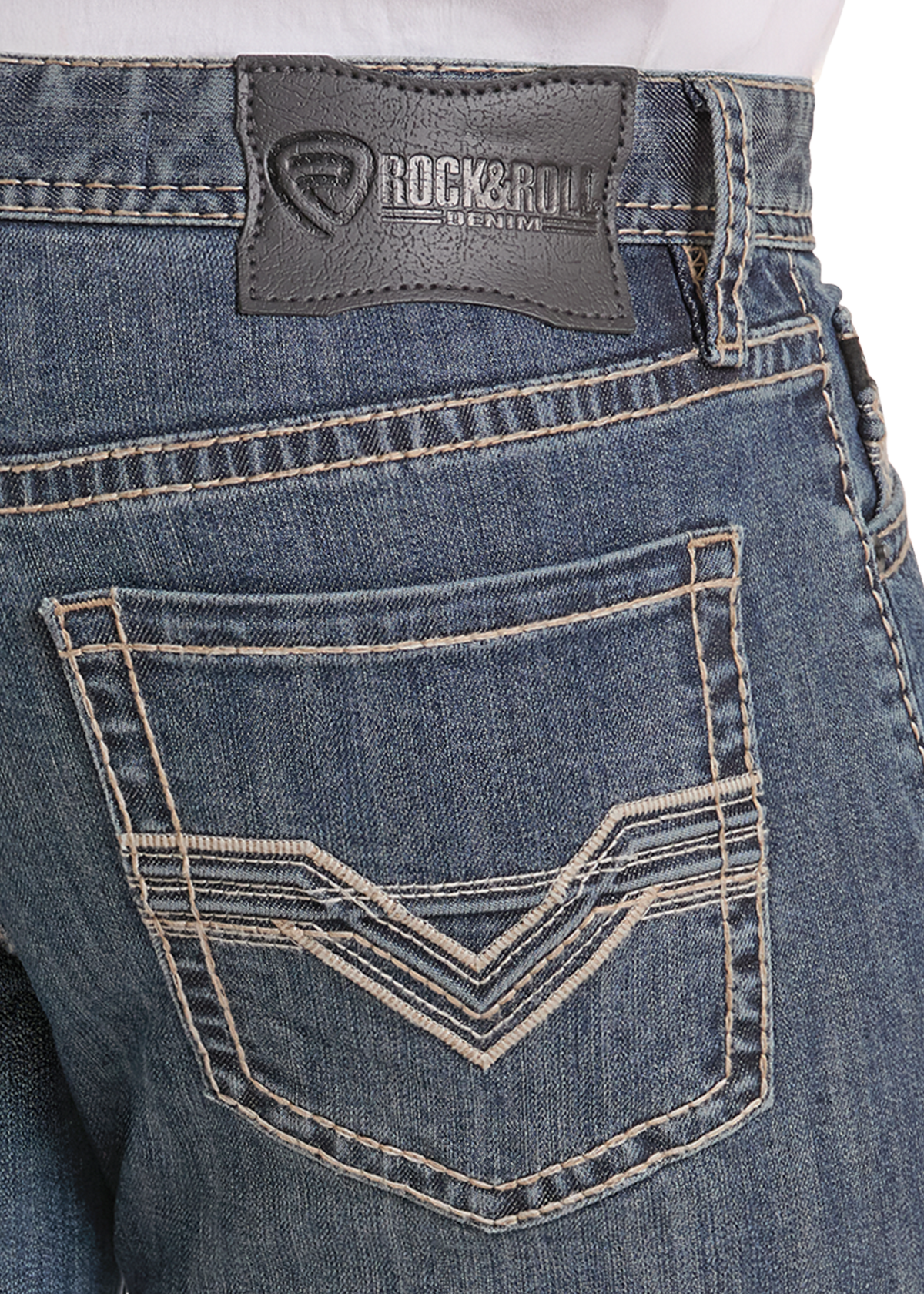 Close-up of the back waistband and pocket area of blue denim jeans, showing a dark gray RockRoll brand patch and contrast stitching.