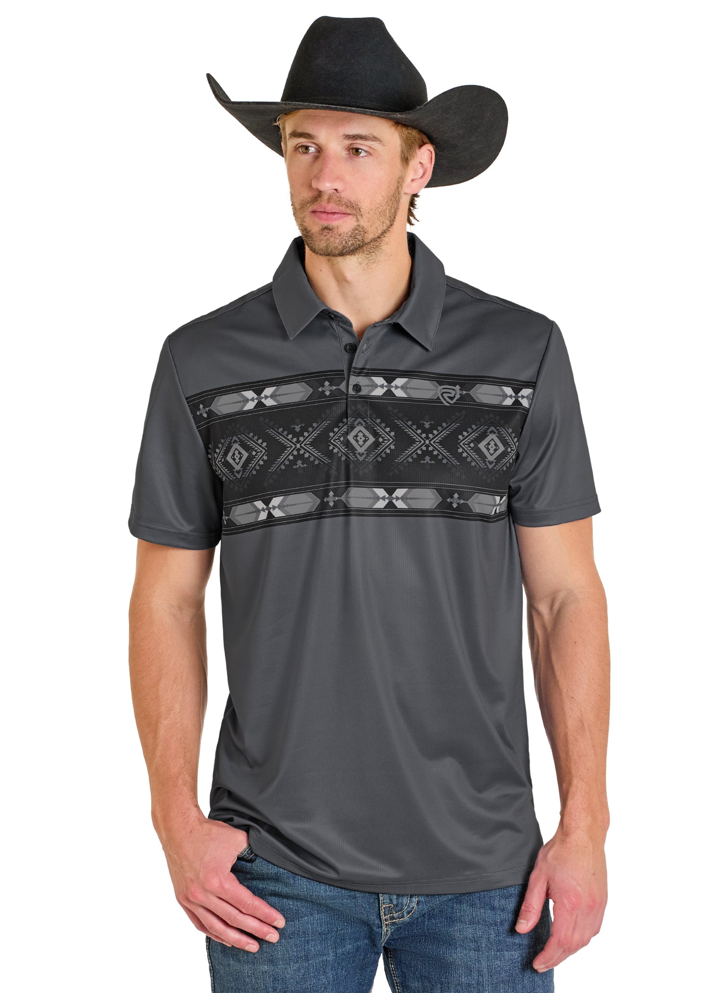 A man wears a black cowboy hat, blue jeans, and the Rock & Roll Denim Grey Diamond Aztec Border Polo featuring a black and white geometric pattern across the chest, standing with one hand in his pocket.