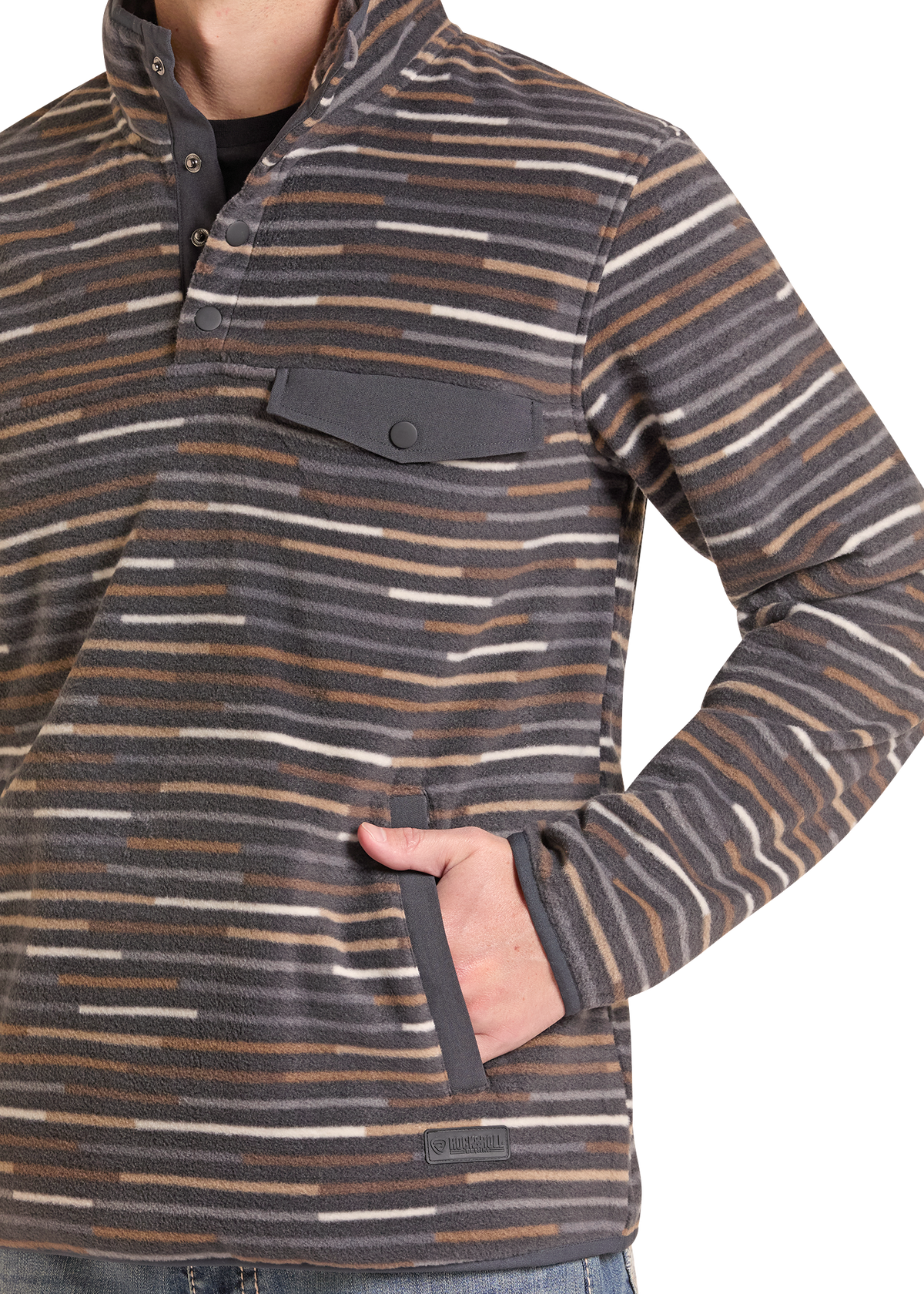 A close-up of a person wearing a long-sleeve quarter-button fleece pullover with a horizontal stripe pattern in dark gray, brown, and off-white. The person has one hand in a side pocket, and the background is solid white.