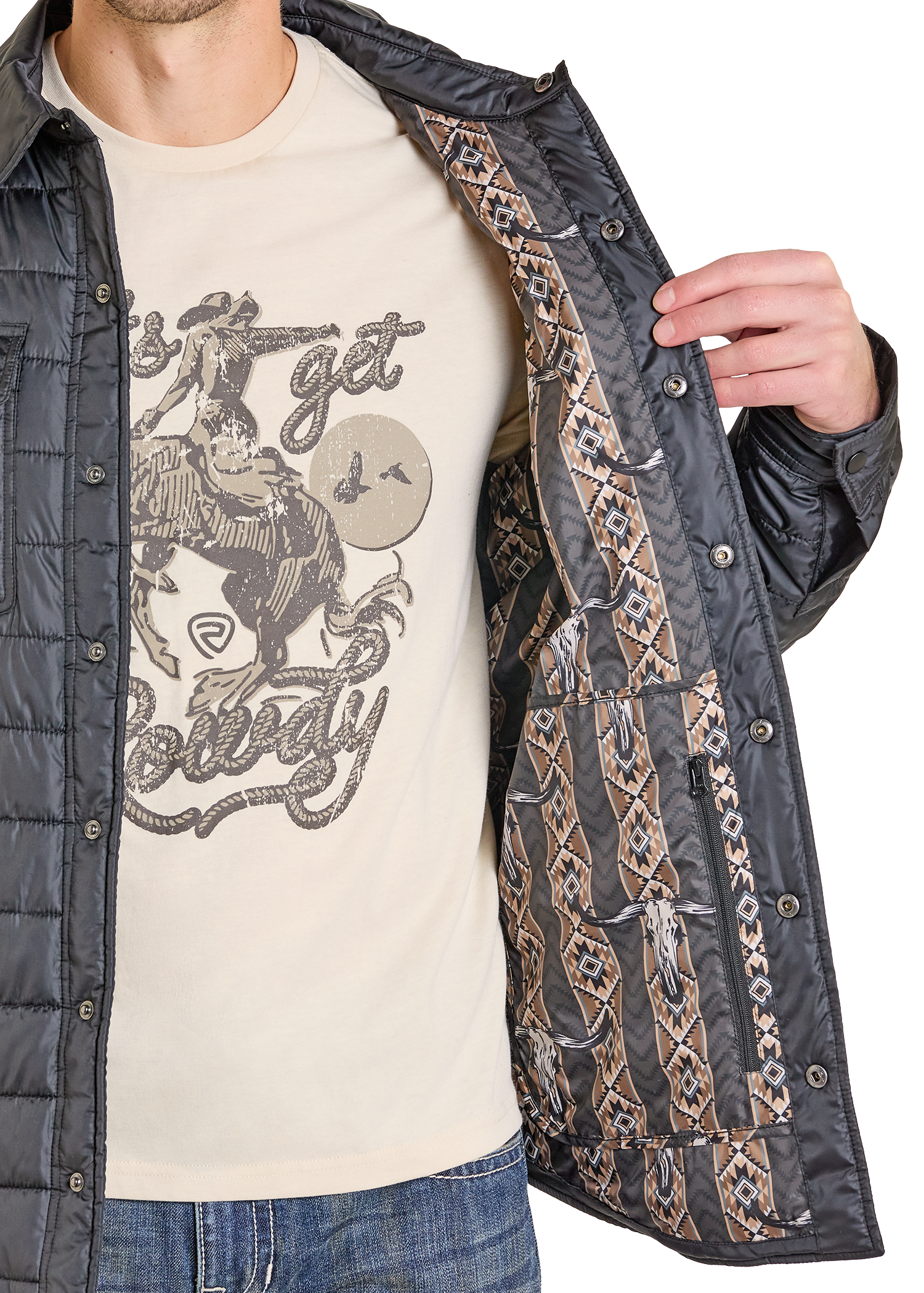 A man in jeans and a graphic tee opens a black Rock & Roll Denim Puffer Print Lined Shirt Jacket, revealing its brown and tan geometric lining. Only the lower part of his face is visible, showcasing the jacket's stylish versatility.
