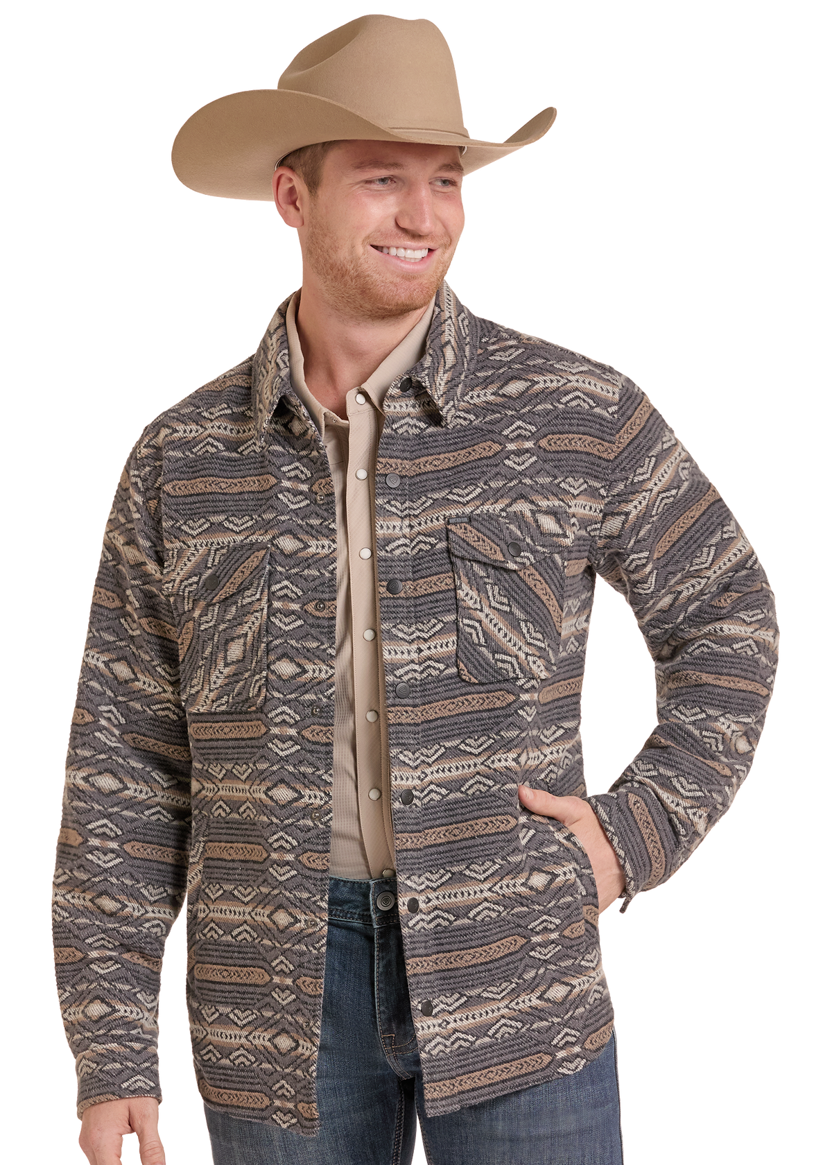 A man wearing a western-style patterned shirt jacket over a tan button-down shirt, blue jeans, and a tan cowboy hat, photographed against a plain white background.
