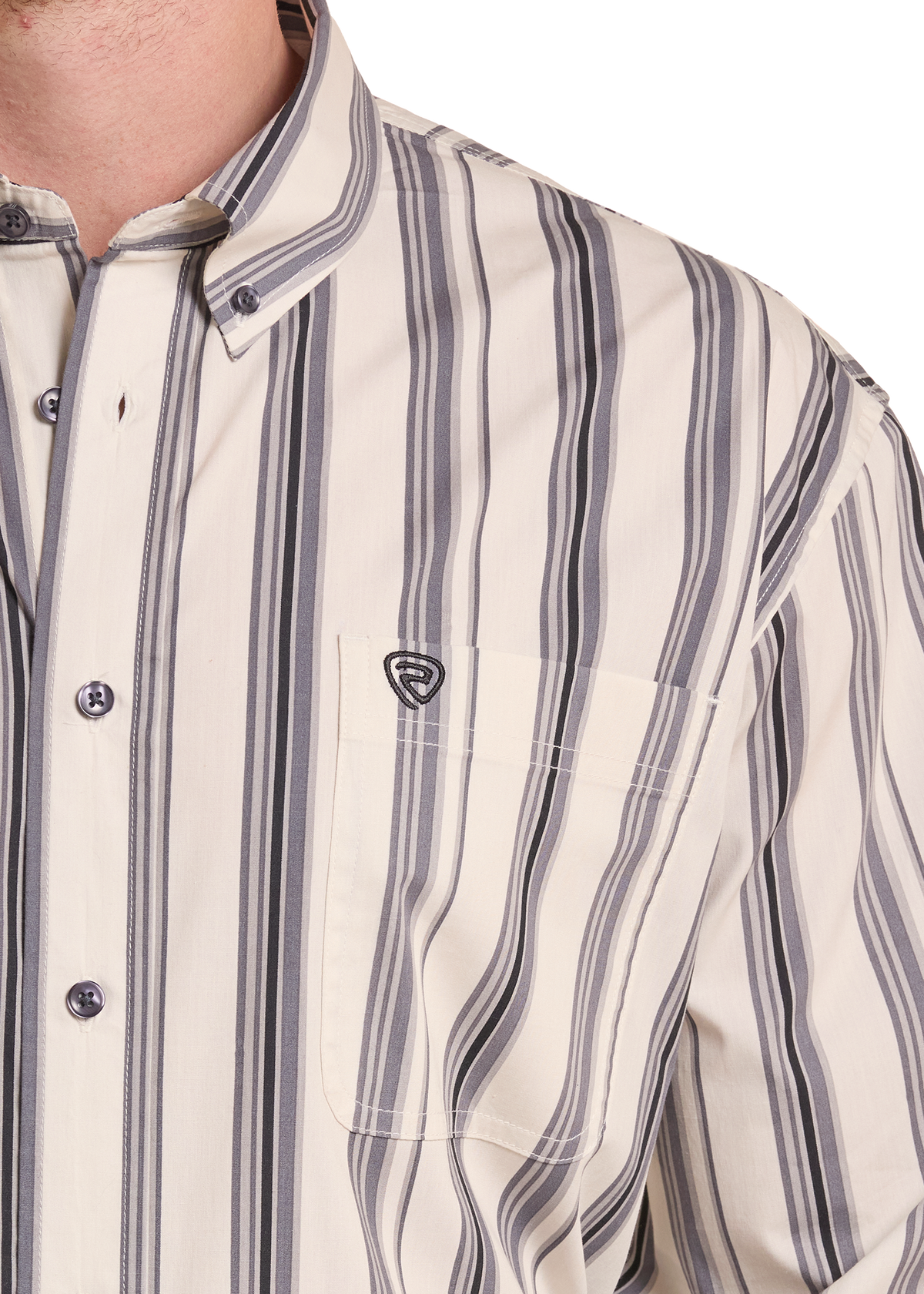 Close-up of a men's long-sleeve button-down shirt with vertical stripes in cream, gray, and black. The shirt features a classic collar, a chest pocket with a small shield logo patch, and dark buttons.