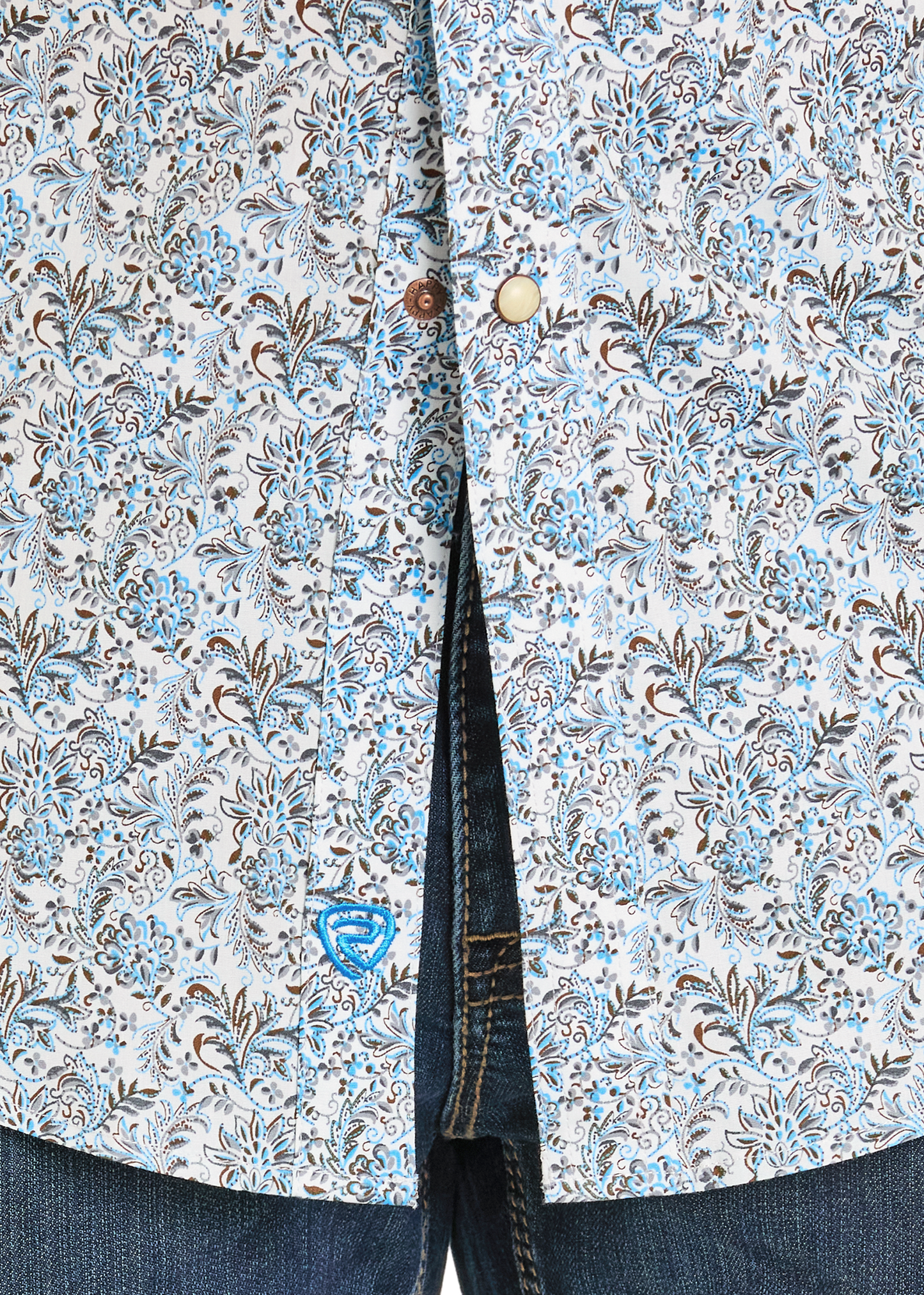 Close-up of a floral patterned shirt with buttons and jeans.