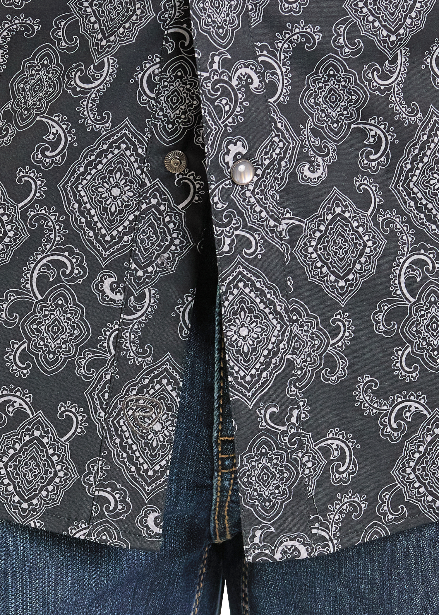 Closeup of a pattered pearl snap shirt. 