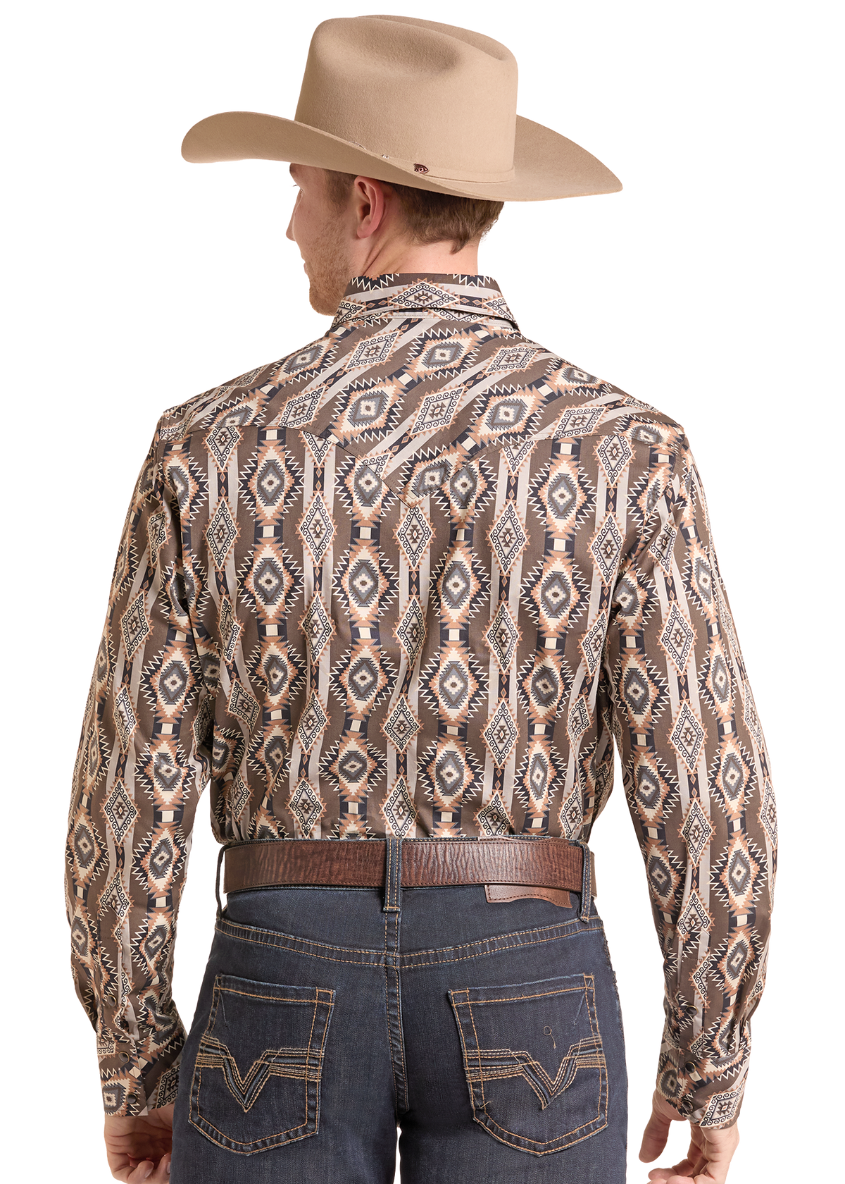 A man viewed from the back wearing a tan cowboy hat, a long-sleeve western shirt with a brown, beige, and gray geometric pattern, a brown belt, and dark blue jeans against a white background.