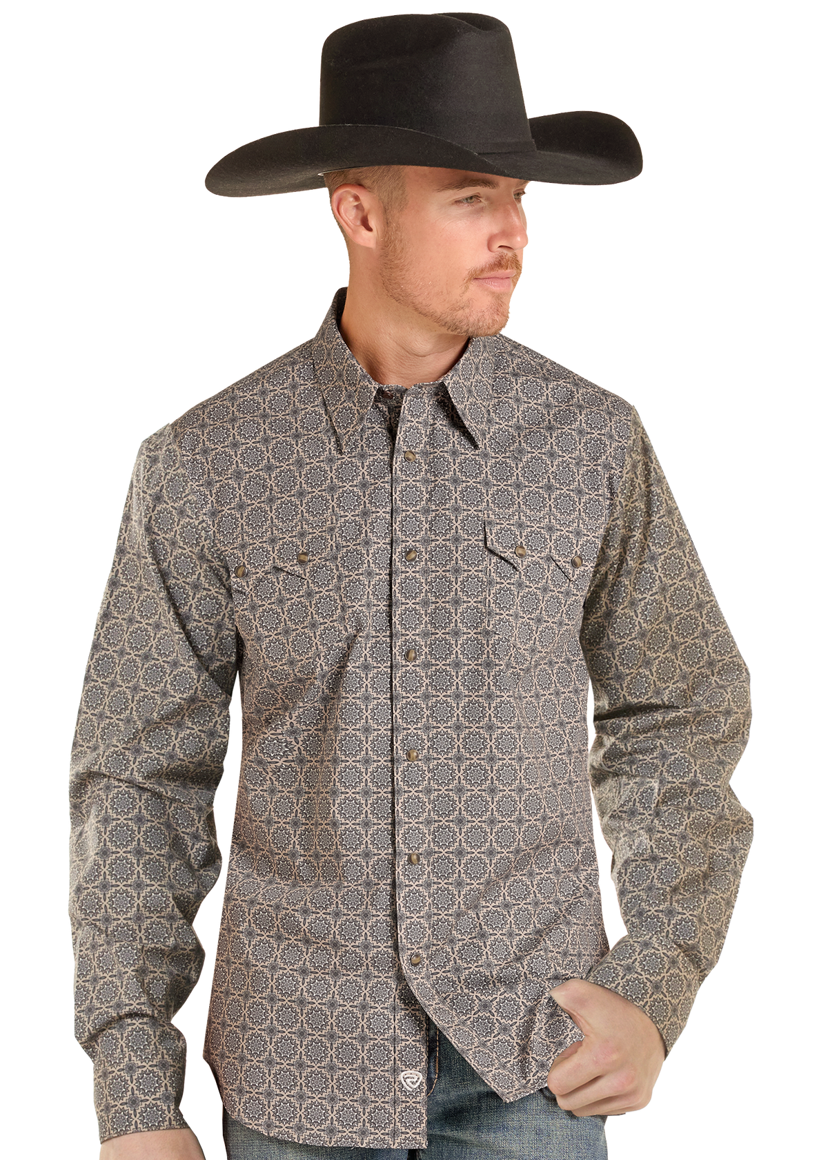 A man wearing a black cowboy hat and a long-sleeve western button-up shirt with a brown and beige geometric pattern, posed against a solid white background.