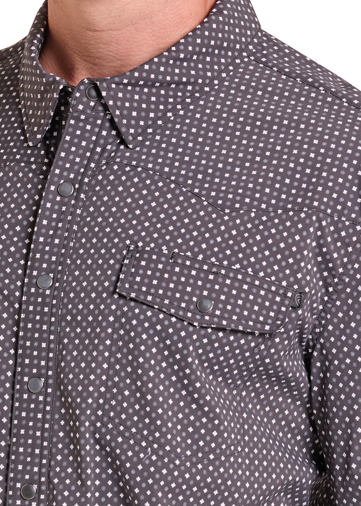 Close-up of a man wearing a dark gray and white micro-patterned button-down shirt, showing the collar, chest pocket, and buttons.