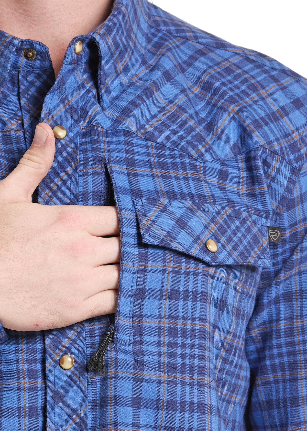 Close-up of a person wearing a blue plaid button-up shirt with a chest pocket and gold-tone snap button, with a hand pulling a zipper on the pocket.