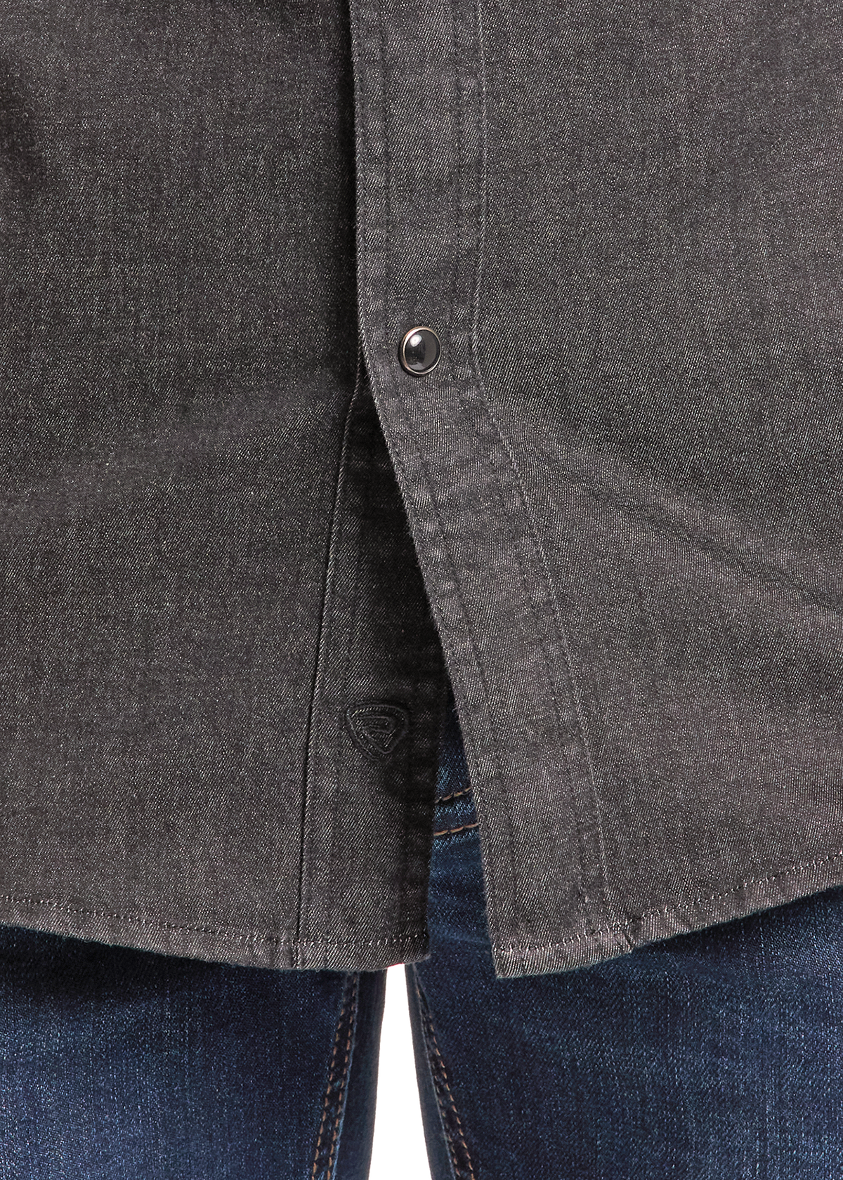 Close-up of a black denim button-down shirt worn over blue jeans, showing the fabric texture and button details.