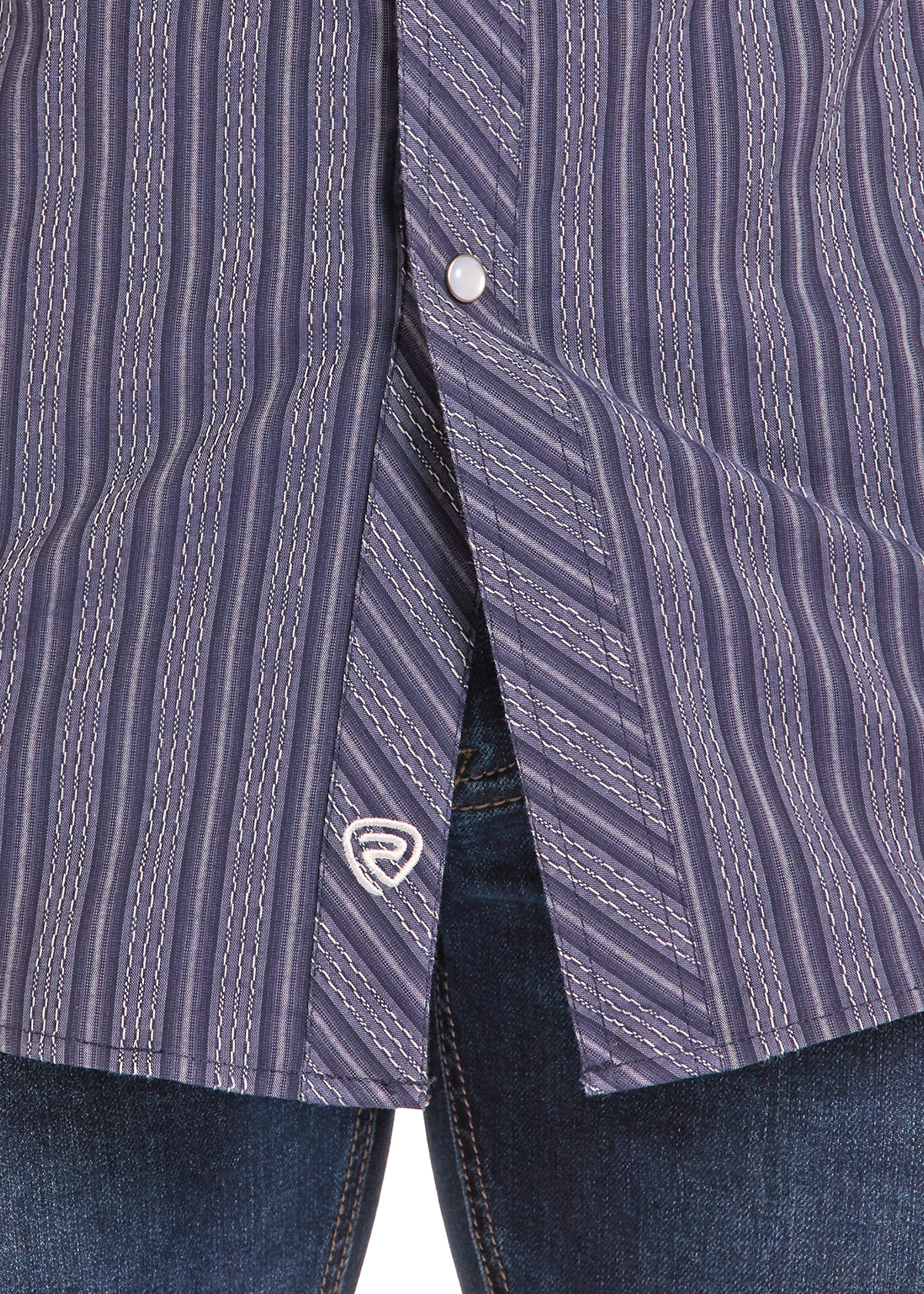 Close-up of a purple and blue striped button-down shirt worn with dark blue jeans, showing the fabric pattern and a small white embroidered logo.