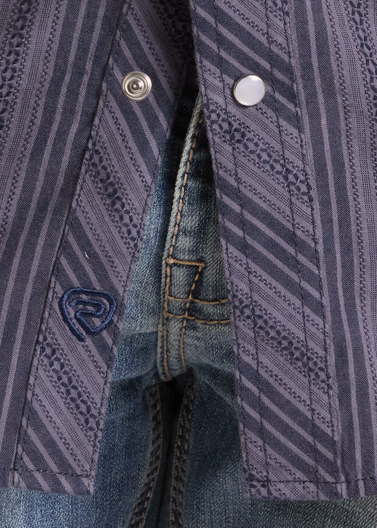 Close-up of a patterned shirt and visible brand logo.