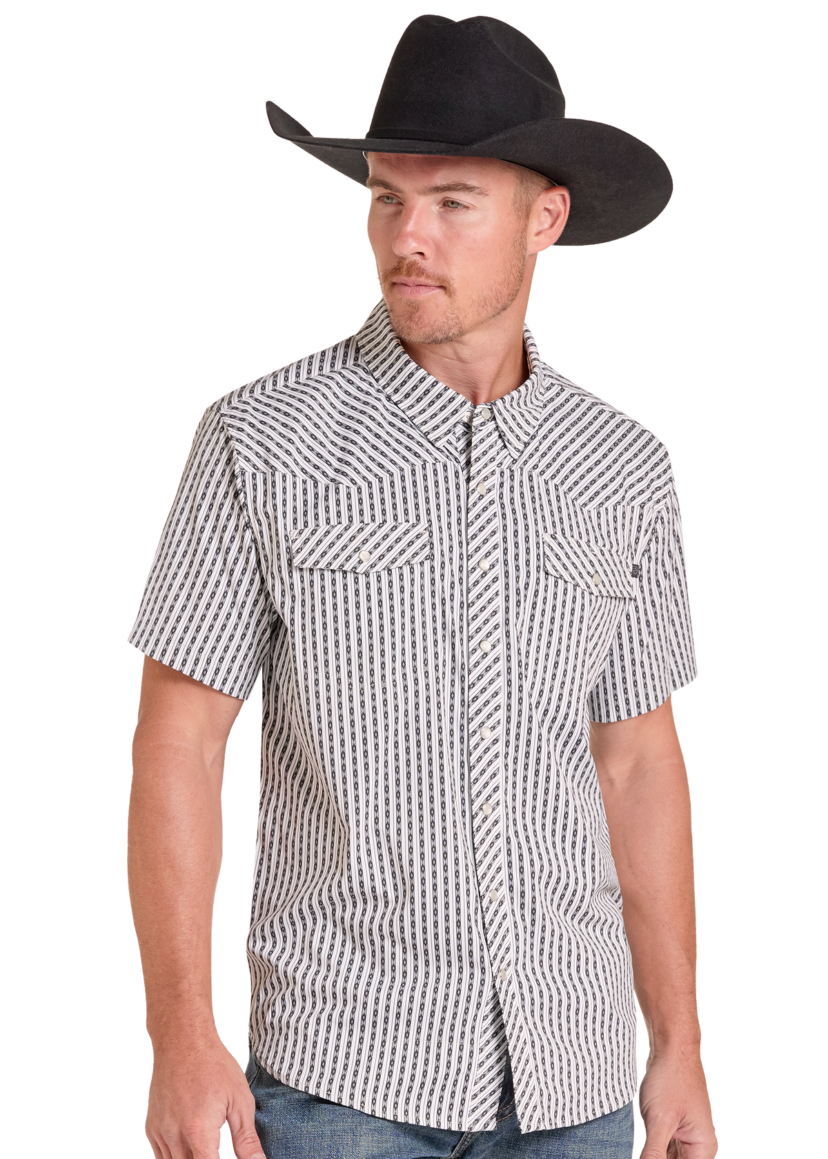 A man wearing a black cowboy hat and a short-sleeve button-up shirt with a black and white geometric pattern, paired with blue jeans, photographed against a solid white background.