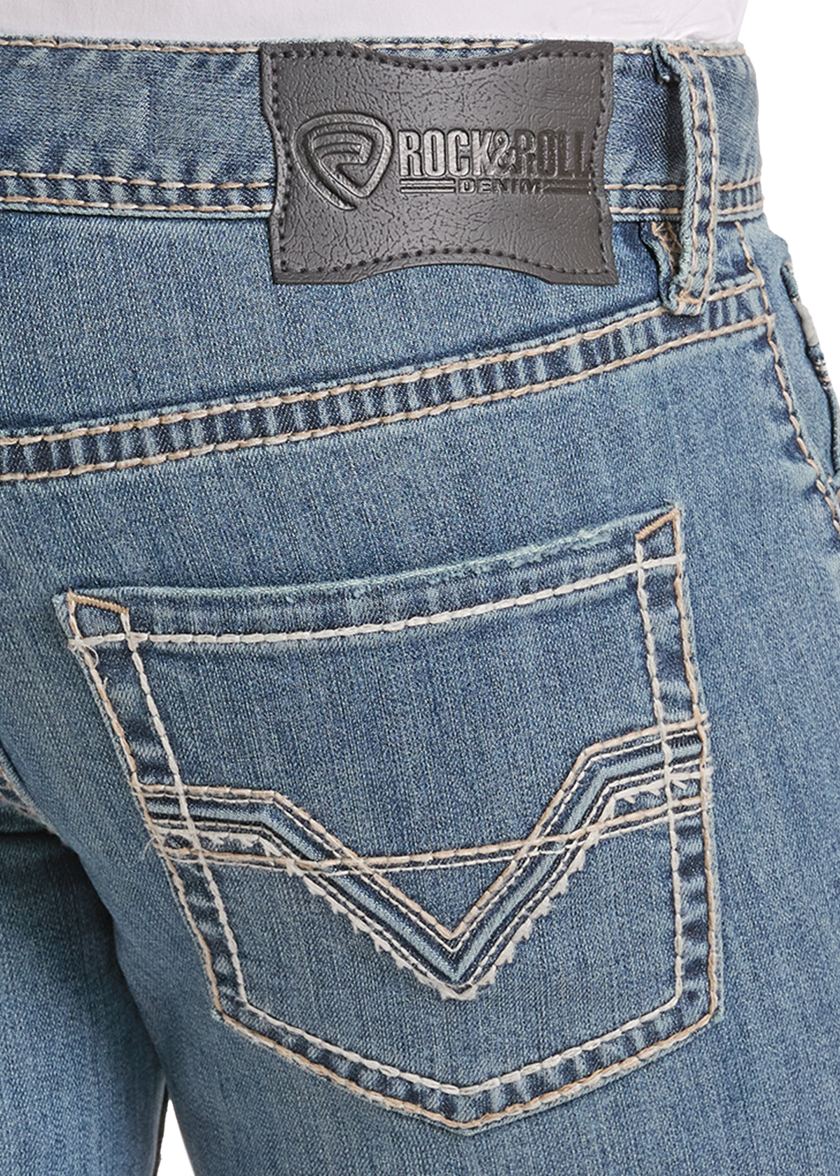 Close-up of the back waistband and rear pocket of blue denim jeans, showing a dark gray Rock & Roll brand patch and contrast stitching.
