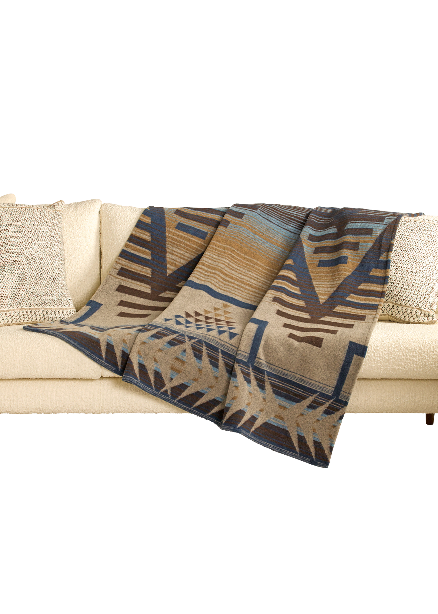 Patterned blanket draped over a couch on a white background