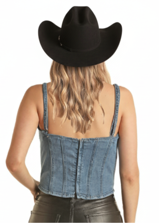 Person wearing a black cowboy hat, denim top, and leather pants on a white background