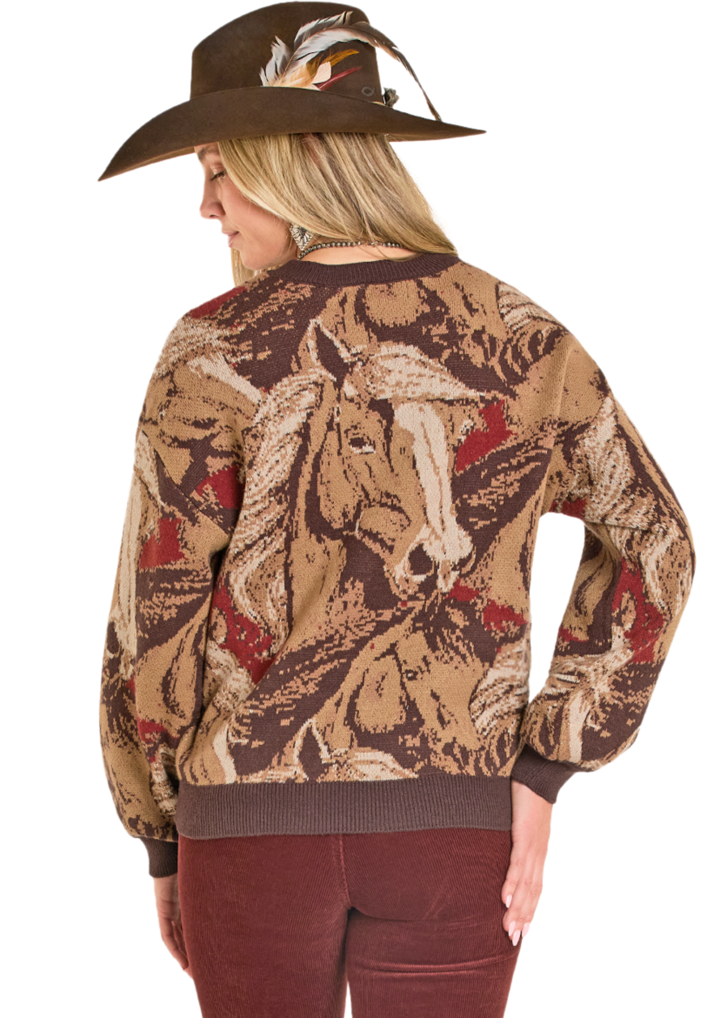 Woman wearing a patterned sweater with horse design and a cowboy hat.