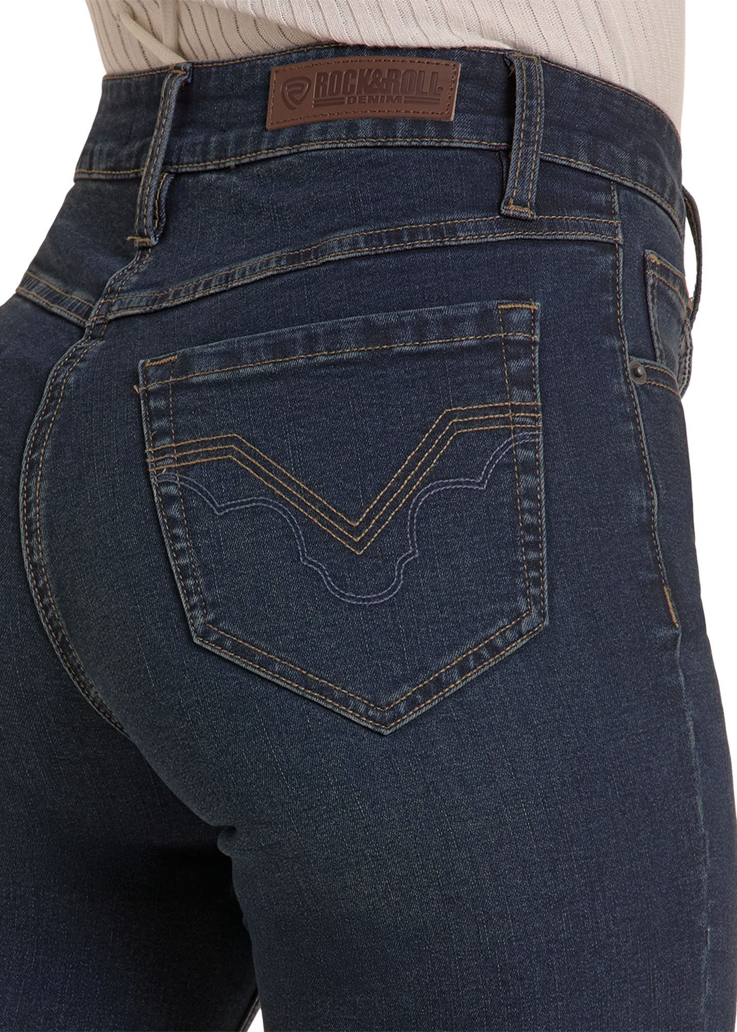 Close-up rear view of a person wearing dark blue denim jeans with a visible Rock and Roll Denim waistband patch and decorative stitching on the back pocket.