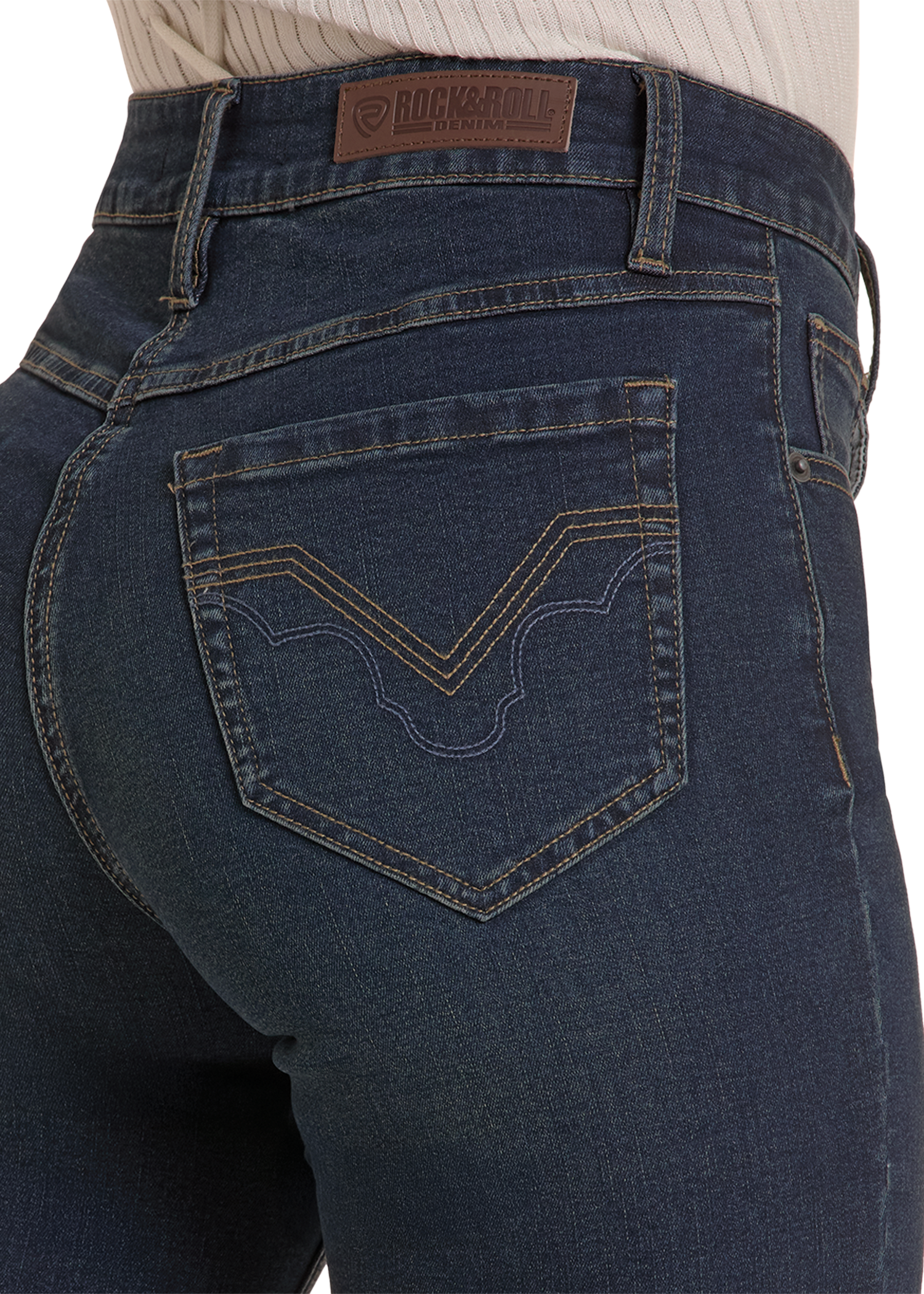 Close-up rear view of a person wearing dark blue denim jeans with a visible Rock and Roll Denim waistband patch and decorative stitching on the back pocket.