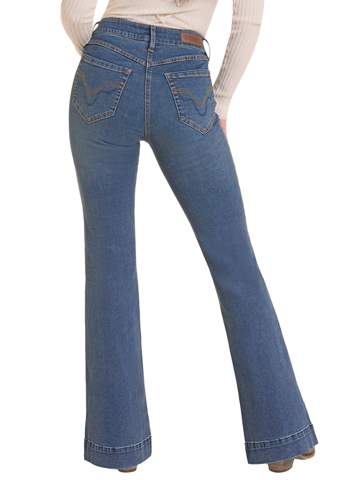 Rear view of a person wearing blue flare jeans with a cream ribbed long-sleeve top, shown against a plain white background.