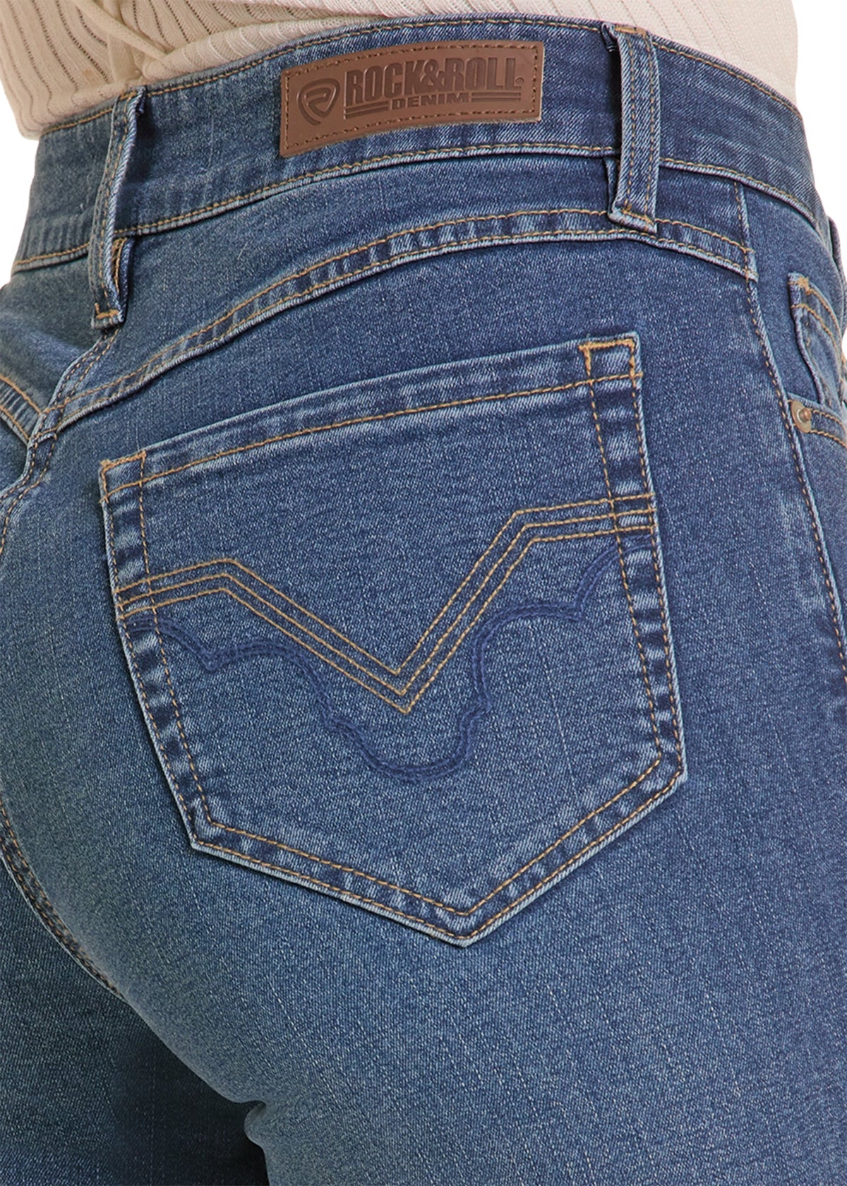 Close-up of the back waistband and pocket area of blue denim jeans, showing a brown Rock & Roll leather patch and contrast tan stitching.