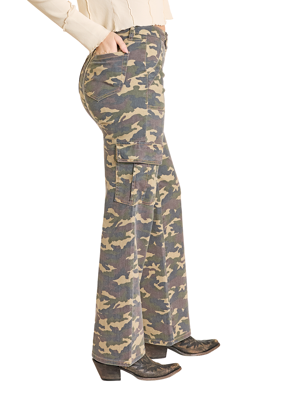 Woman wearing a beige long-sleeve top and camouflage flared pants with a cowboy hat on a white background