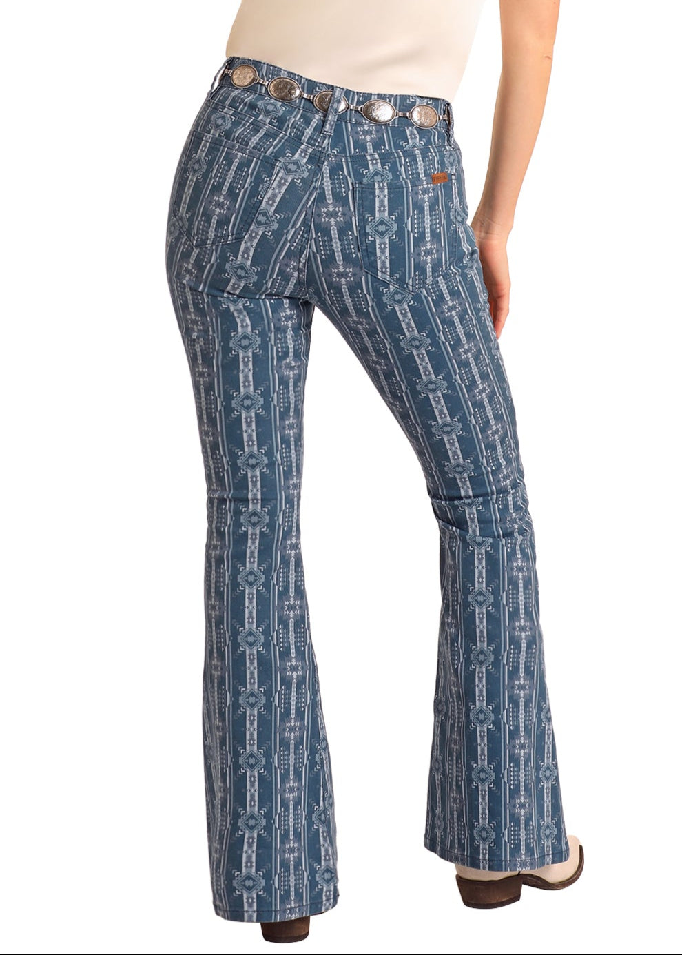 Woman wearing blue patterned pants and a beige hat on a white background