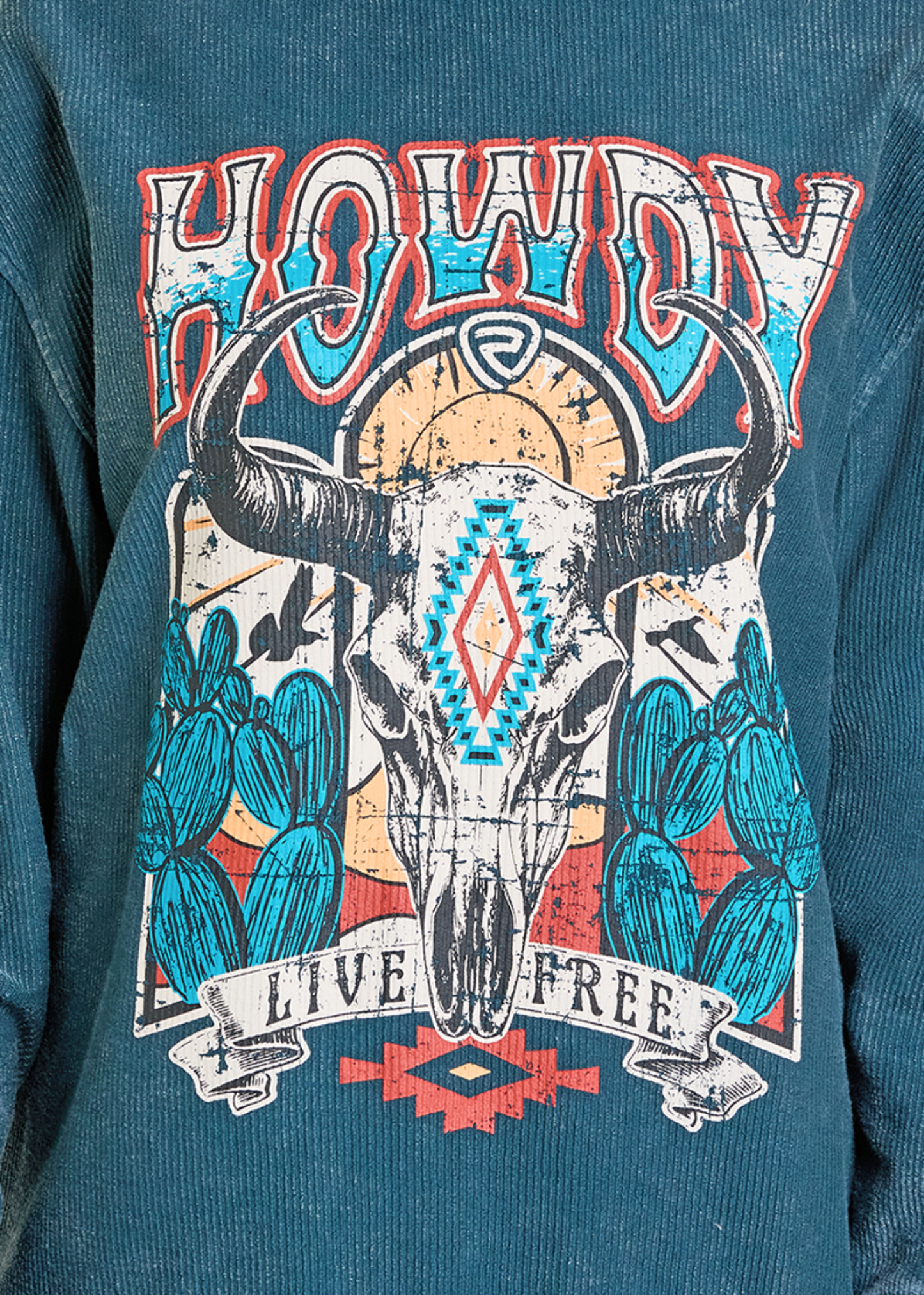 Teal sweatshirt with a graphic design featuring a bull skull, cacti, and 'Howdy Live Free' text on a blue background.
