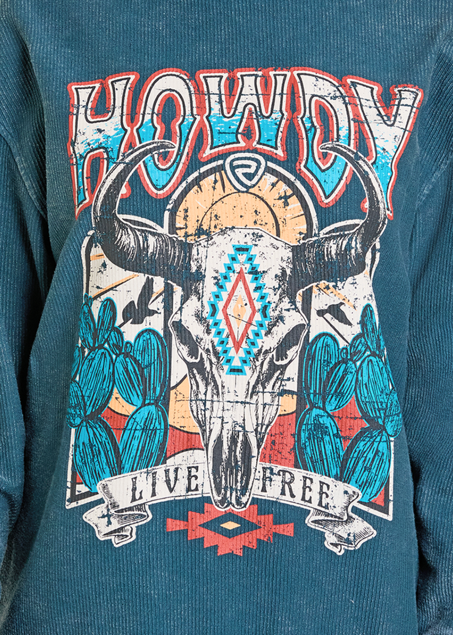Teal sweatshirt with a graphic design featuring a bull skull, cacti, and 'Howdy Live Free' text on a blue background.