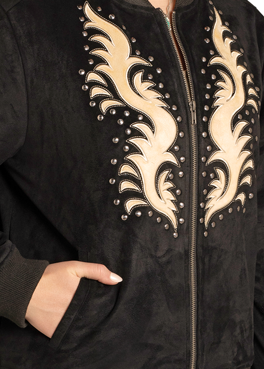 A model wears the Rock & Roll Denim Microsuede Studded Applique Bomber Jacket, featuring a black body with tan flame embroidery and metal studs, shown from shoulders to waist with one hand in the pocket.