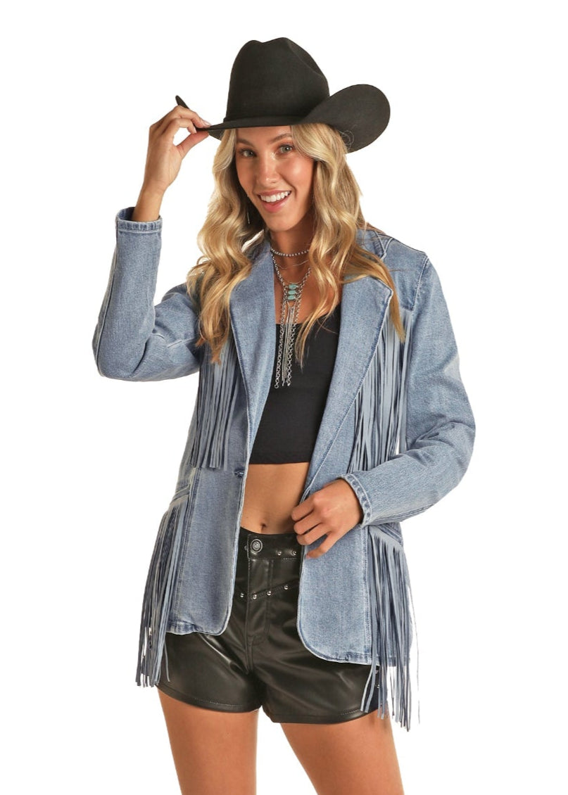 Woman wearing a denim jacket, black shorts, and gray boots on a white background