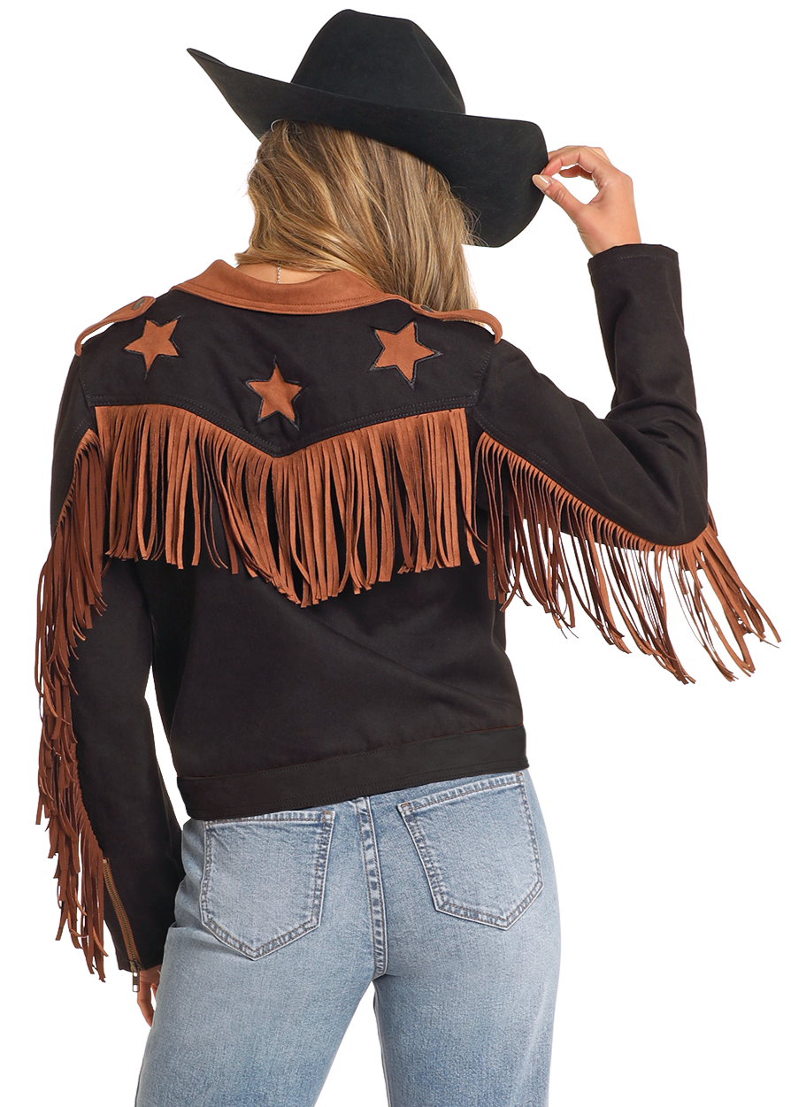 Person wearing a black cowboy hat, black shirt with fringes and star designs, and blue jeans on a white background.