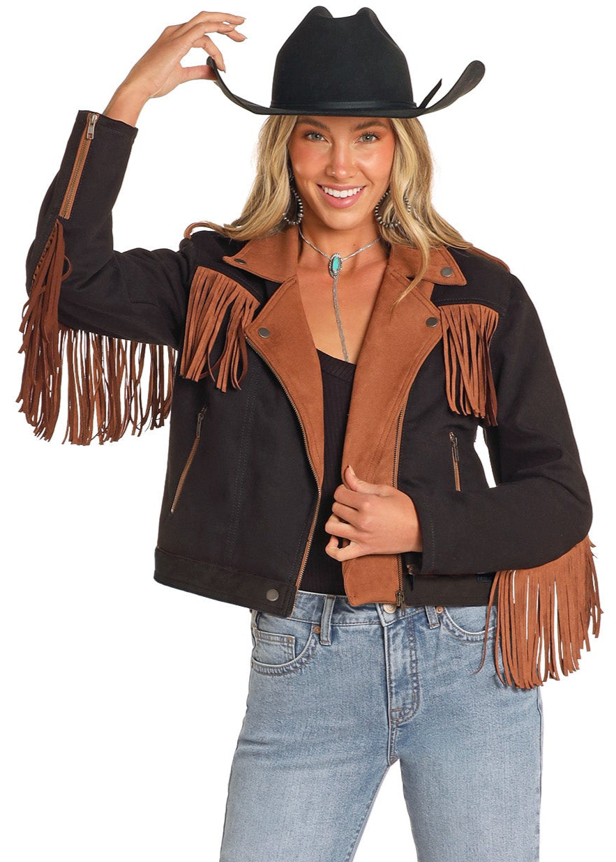Woman wearing a black leather jacket with brown fringe, blue jeans, and a cowboy hat on a white background