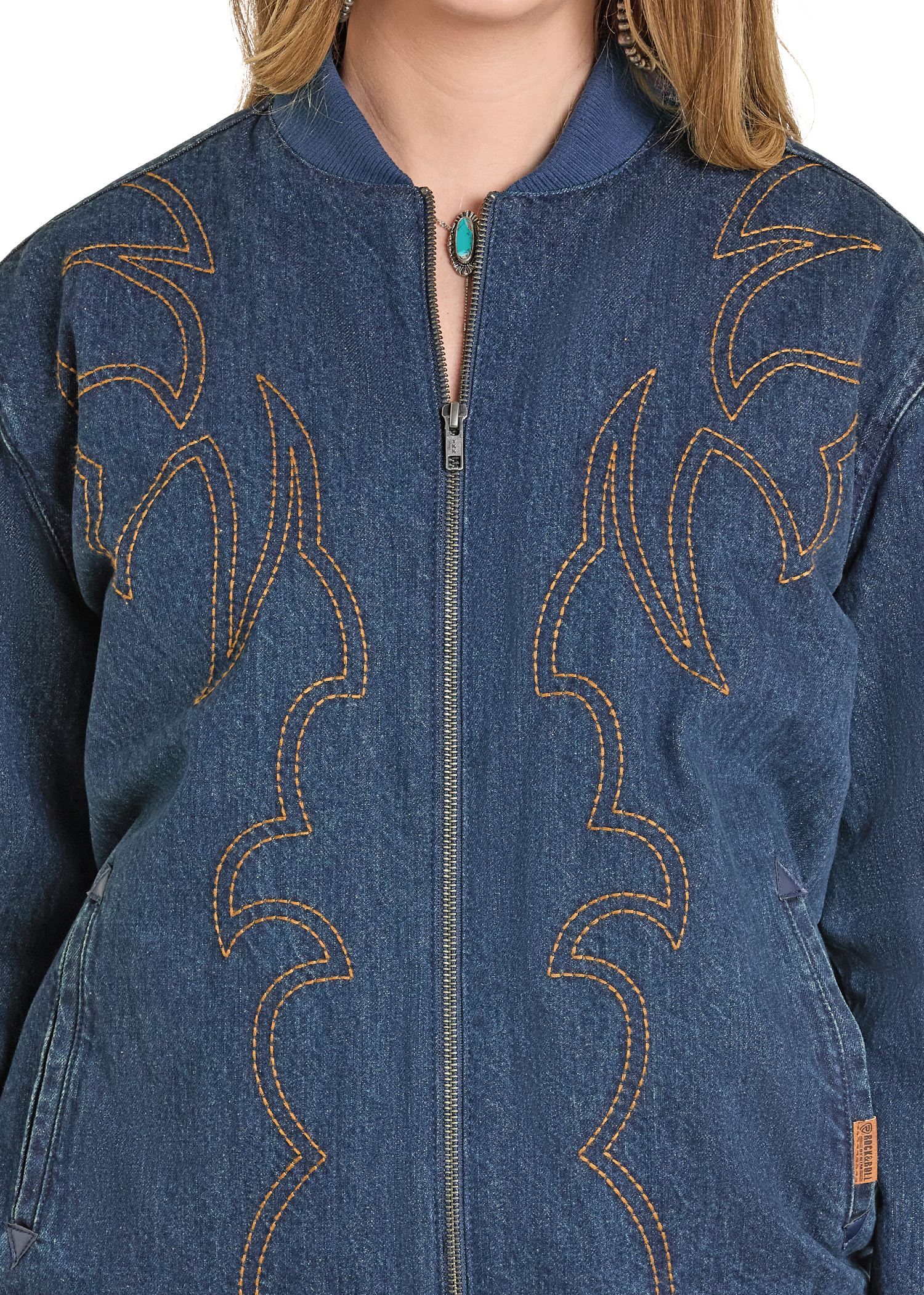 Close-up of a blue denim jacket with intricate stitching details.