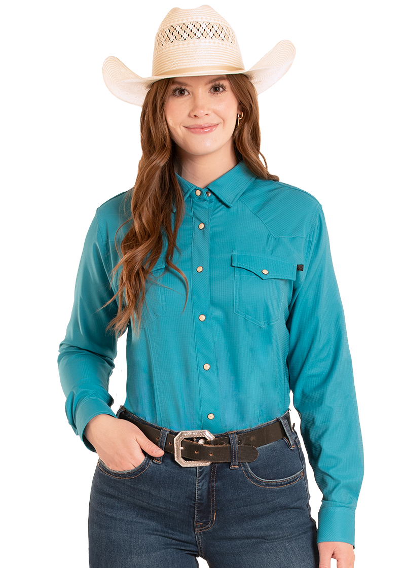 Woman wearing a turquoise long-sleeve shirt, jeans, and a cowboy hat on a white background