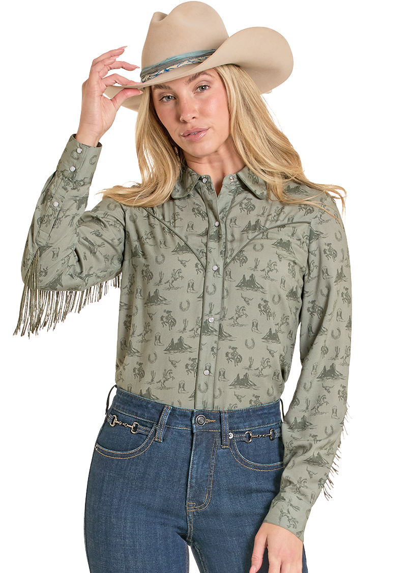 Woman wearing a patterned shirt with fringes and a cowboy hat on a white background