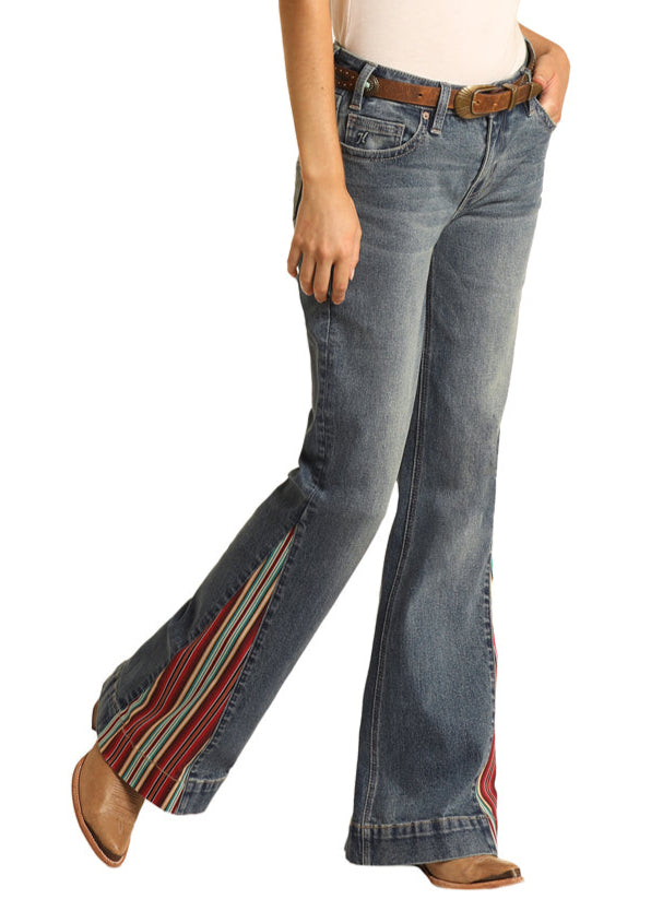 Woman wearing a white shirt, blue jeans with side stripes, and a cowboy hat on a white background